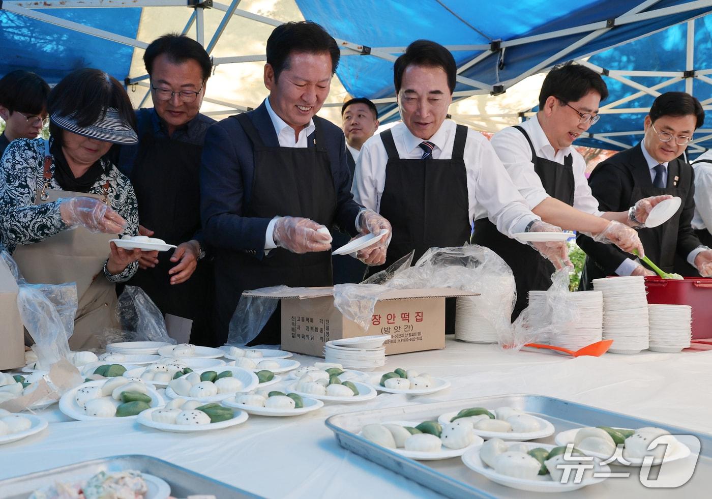 본문 이미지 - 1일 어버이날 기념 경로행사가 열린 충남 서산시문화회관 주차장에서 더불어민주당 정청래 대표와 박수현 충남도지사 후보, 맹정호 서산시장 후보가 음식 준비를 하고 있다.(제공. 재판매 및 DB금지)2026.5.1 ⓒ 뉴스1 김태완 기자