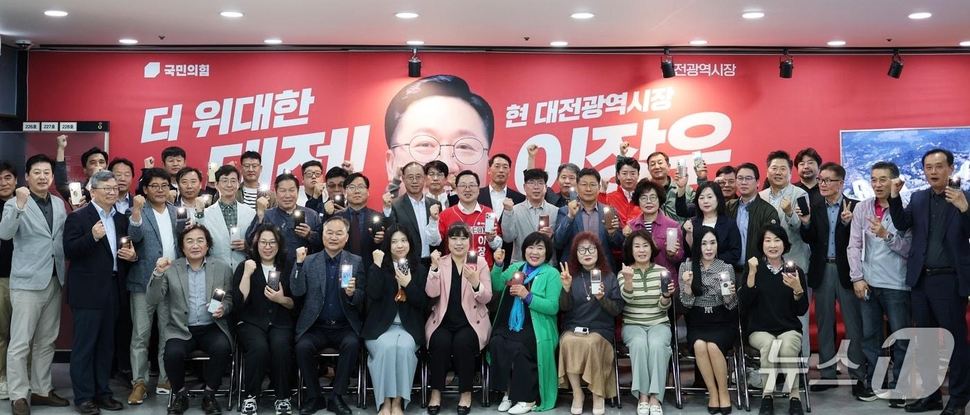 본문 이미지 - 이장우 대전시장 후보가 선거대책본부장 회의에서 참석자들와 포즈를 취하고 있다.(후보 캠프 제공. 재판매 및 DB금지)/뉴스1