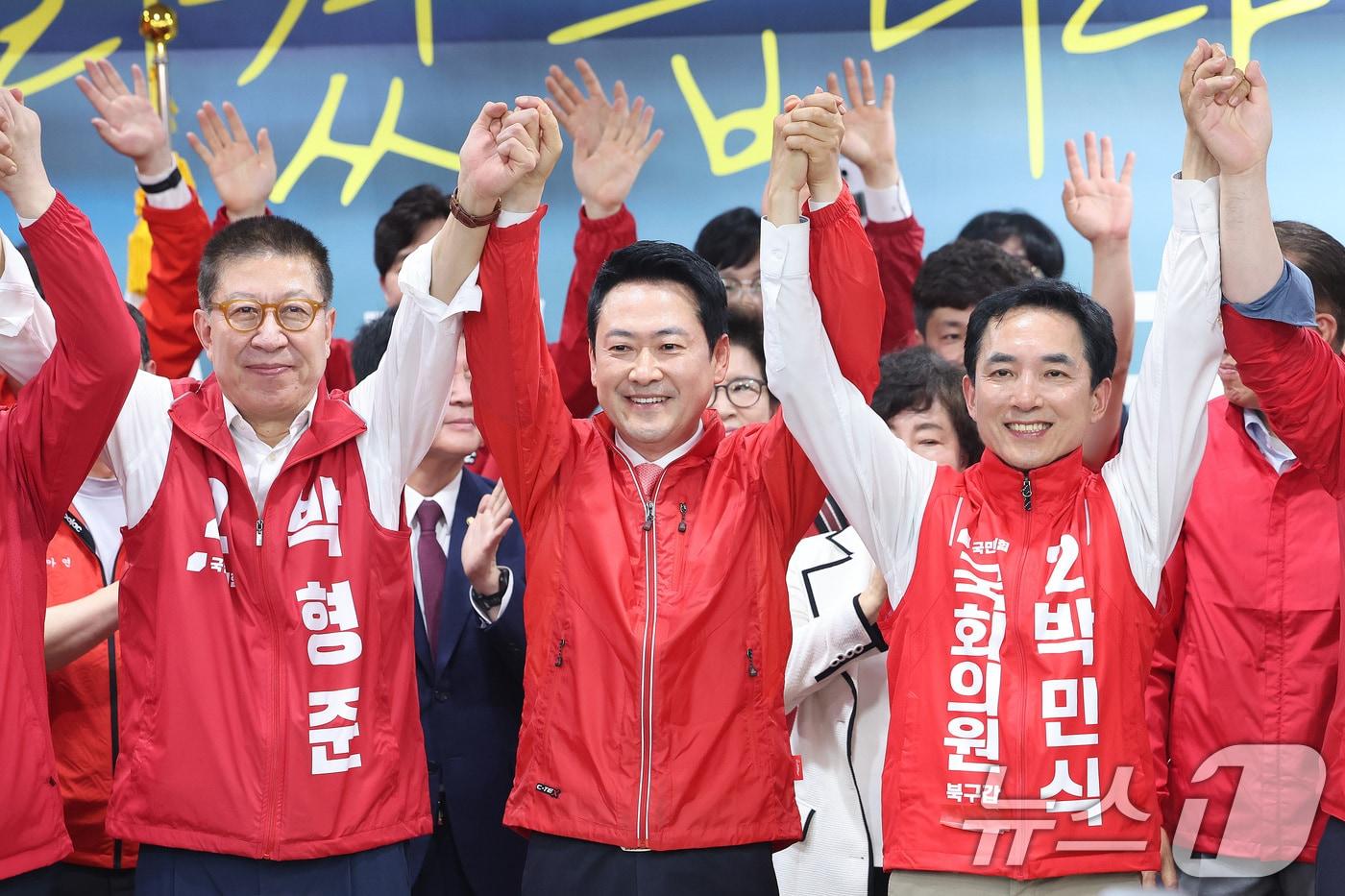 본문 이미지 - 장동혁 국민의힘 대표가 10일 부산 북구에서 열린 박민식 부산 북갑 국회의원 후보 선거사무소 개소식에서 박 후보, 박형준 부산시장 후보와 손을 맞잡고 있다. 2026.5.10 ⓒ 뉴스1 신웅수 기자