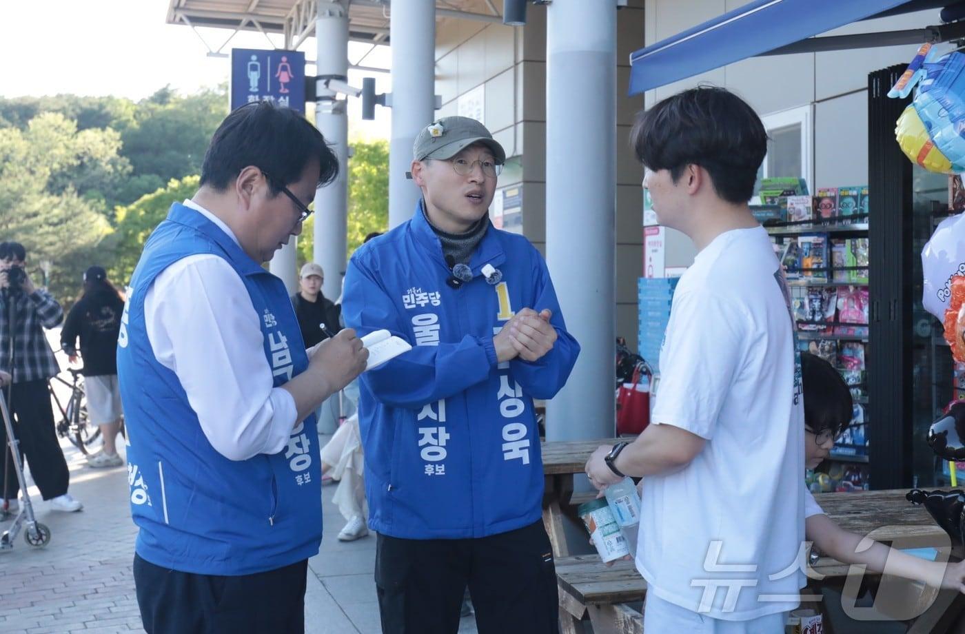 본문 이미지 - 선거사무소 개소식을 생략한 김상욱 더불어민주당 울산시장 예비후보가 10일 울산대공원 정문 광장에서 시민과 만나 통학 문제에 대해 논의하고 있다.2026.5.10. ⓒ 뉴스1 김세은 기자