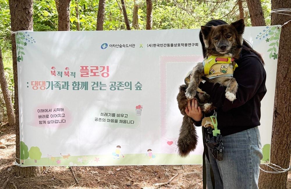 본문 이미지 - 한국인간동물상호작용연구회가 아차산숲속도서관과 함께 진행한 '북적북적 플로깅' 행사에 참여한 반려가족이 기념 사진을 찍고 있다(카이 제공). ⓒ 뉴스1