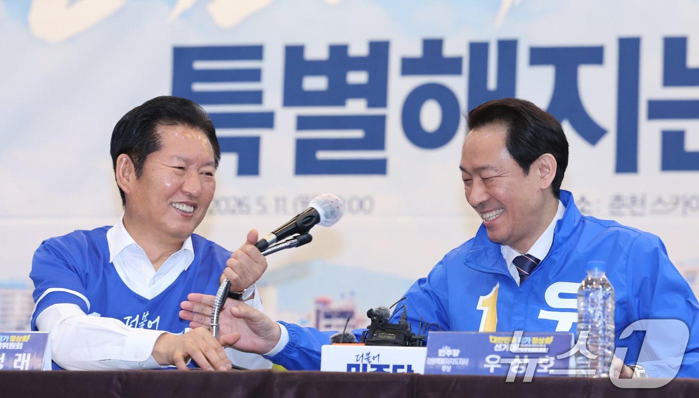 본문 이미지 - 정청래 더불어민주당 대표가 11일 강원 춘천시 스카이컨벤션에서 열린 현장 중앙선거대책위원회의에서 우상호 강원도지사 후보에게 마이크를 건네주고 있다. 2026.5.11 ⓒ 뉴스1 신웅수 기자