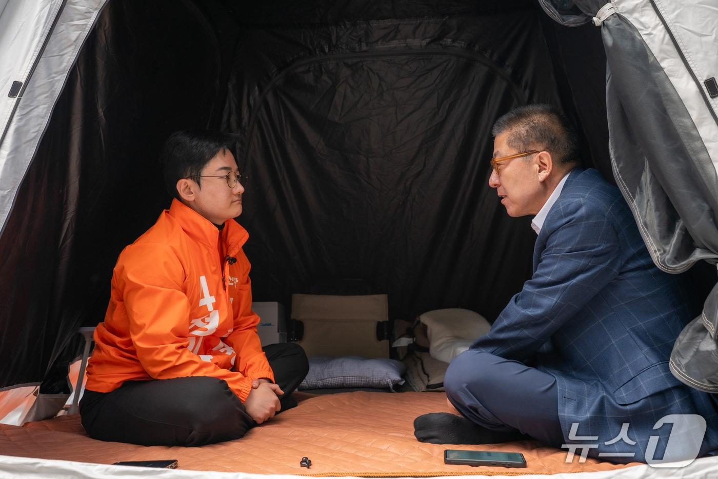 본문 이미지 - 박형준 국민의힘 부산시장 후보(오른쪽)가 11일 부산 부산시청 앞에서 단식 농성 중인 정이한 개혁신당 부산시장 후보를 찾아 위로하고 있다.(정이한 선거캠프 제공. 재판매 및 DB금지)