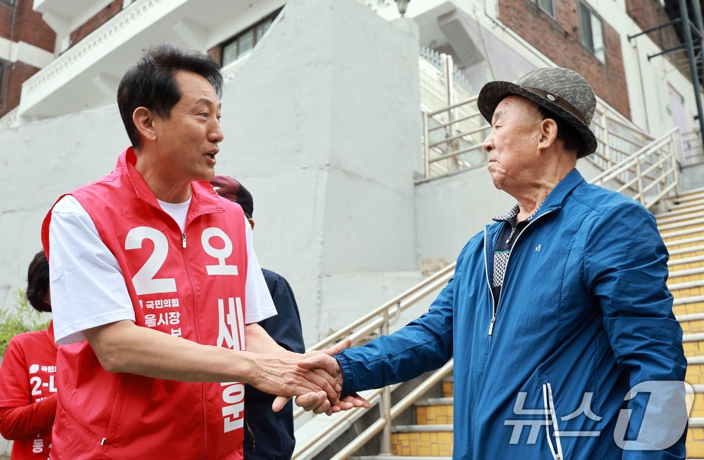 본문 이미지 - 오세훈 국민의힘 서울시장 후보가 11일 서울 구로구 고지대 주택가 일대를 찾아 어르신과 악수를 나누고 있다. 2026.5.11 ⓒ 뉴스1 이호윤 기자