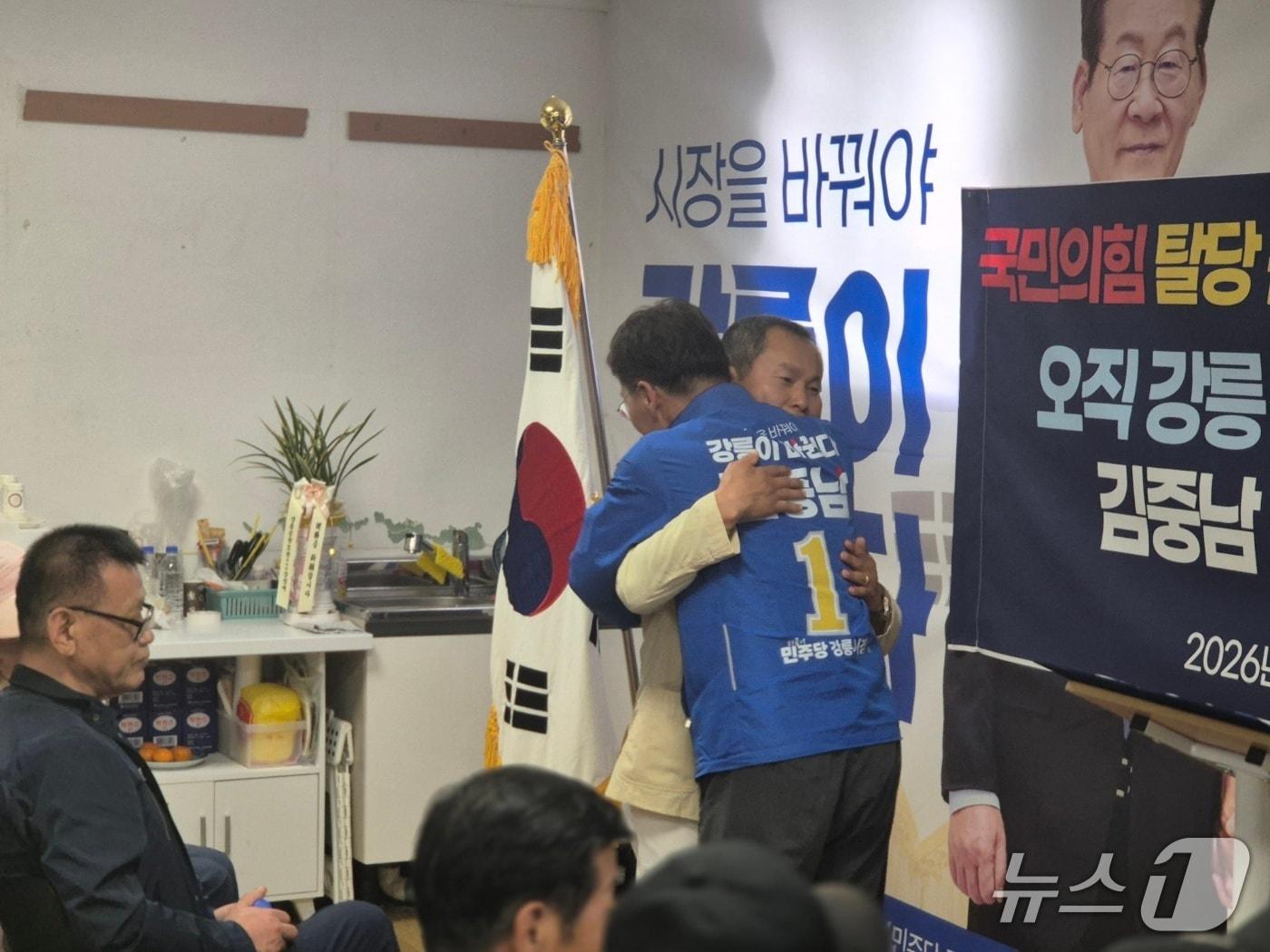 본문 이미지 - 11일 오후 김중남 더불어민주당 강원 강릉시장 예비후보(사진 뒷모습)가 권혁민 씨를 공동선거대책본부장에 임명한 뒤 포옹하고 있다. 권 씨는 자신을 국민의힘 강릉시장 예비후보 캠프에 있었던 인사라고 소개했다.2026.5.11/뉴스1