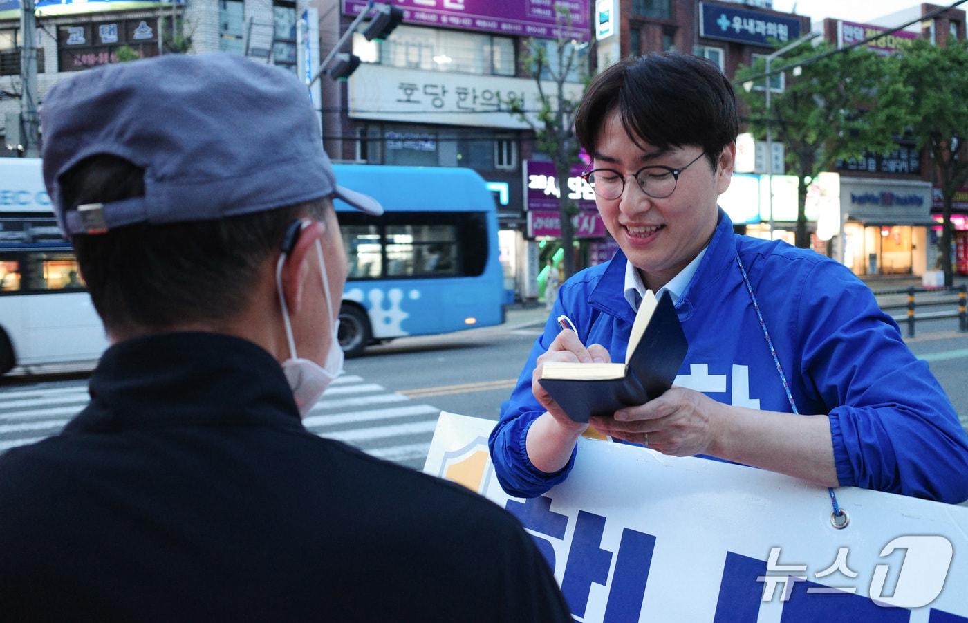 본문 이미지 - 하정우 더불어민주당 부산 북구갑 후보가 11일 부산 북구 만덕동에서 퇴근길 인사 중 지나가는 시민의 요청 사항을 수첩에 받아적고 있다. 2026.05.11 ⓒ 뉴스1 김세정 기자