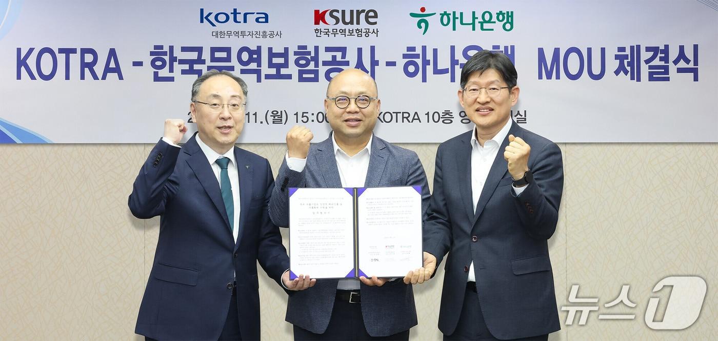 본문 이미지 - 지난 11일 코트라 본사에서 진행된 협약식에서 이정현 외환사업단 상무(사진 왼쪽)가 강상엽 코트라 부사장(사진 가운데), 장진욱 한국무역보험공사 부사장(사진 오른쪽)과 함께 협약서를 들고 기념 촬영을 하고 있다. 2026.05.11 / 사진제공=하나은행