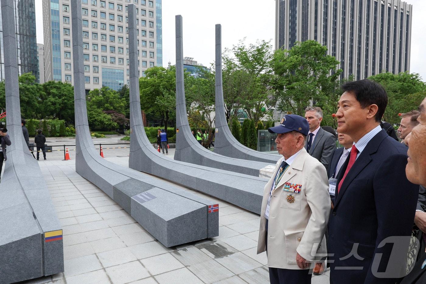 본문 이미지 - 오세훈 국민의힘 서울시장 후보가 12일 서울 종로구 광화문광장에서 열린 '감사의 정원 준공식'에 참석해 6.25 참전유공자와 석재 조형물을 보고 있다. 감사의 정원은 6.25 전쟁 참전국에 대한 예우를 담아 조성한 공간으로 미국, 캐나다, 영국 등 22개국과 한국을 포함한 23개 석재 조형물 및 지하 미디어 전시 공간으로 구성됐다. (공동취재) 2026.5.12 ⓒ 뉴스1 임세영 기자