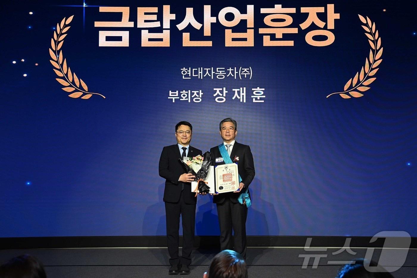 본문 이미지 - 문신학 산업통상부 차관이 12일 오전 서울 서초구 JW메리어트호텔에서 열린 제23회 자동차의 날 기념식에서 장재훈 현대자동차 부회장에게 금탑산업훈장을 수여하고 기념 촬영을 하고 있다. (산업통상부 제공. 재판매 및 DB 금지) 2026.5.12 ⓒ 뉴스1
