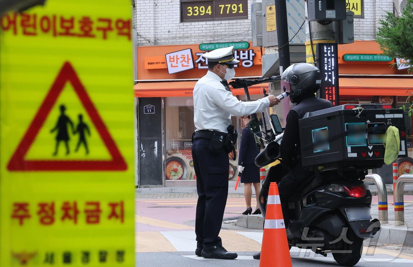 본문 이미지 - 동대문경찰서 경찰관들이 12일 서울 동대문구 장평초등학교 앞에서 스쿨존 하굣길 교통법규위반 집중단속을 하고 있다. 2026.5.12 ⓒ 뉴스1 김성진 기자