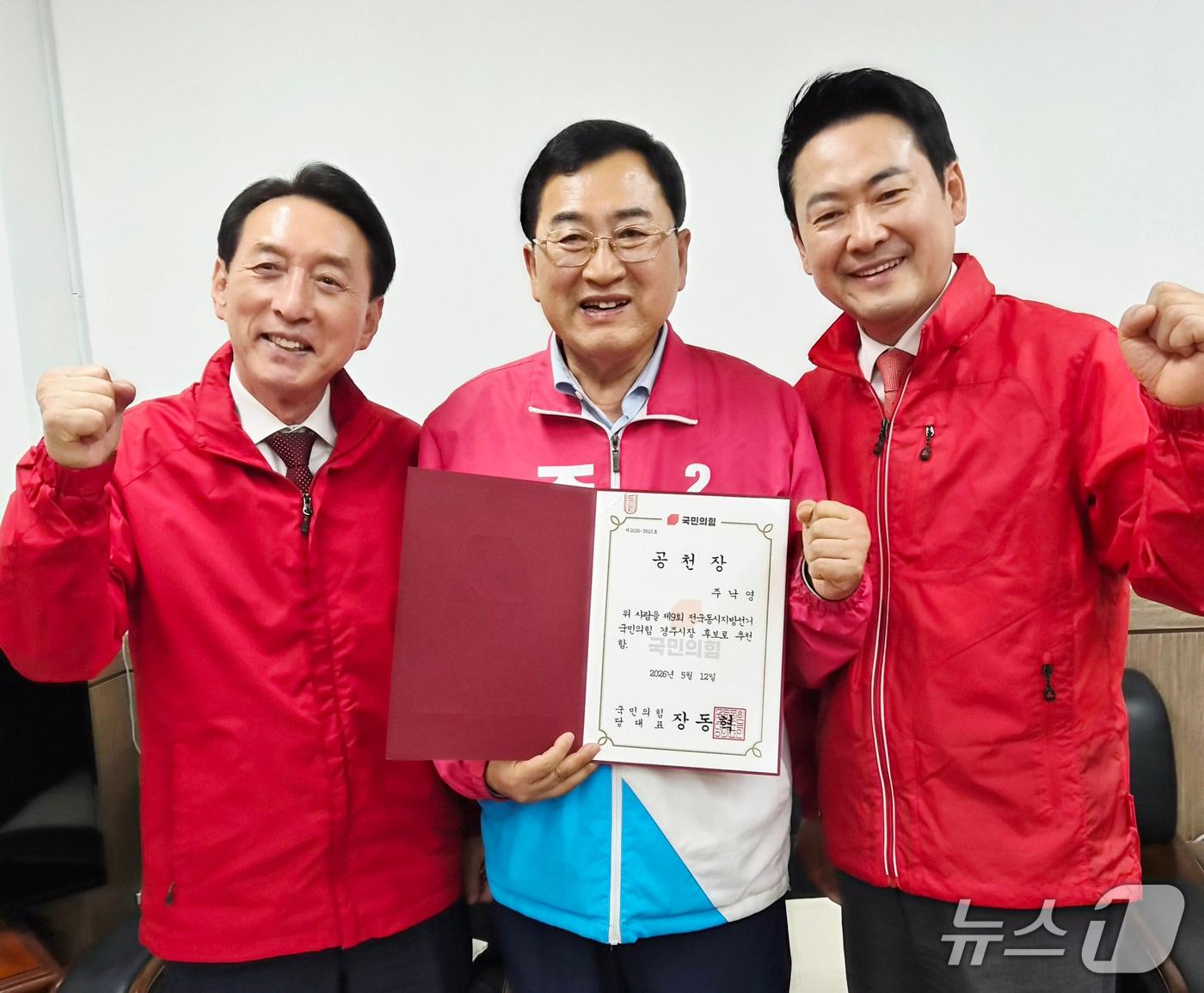 본문 이미지 -  주낙영 경북 경주시장 예비후보가 장동혁 국민의힘 대표(오른쪽)와 김석기 지역 국회의원으로부터 공천장을 받은 후 압승을 다짐하고 있다. (국민의힘 경북도당 제공, 재판매 및 DB금지) 2026.5.12/뉴스1
