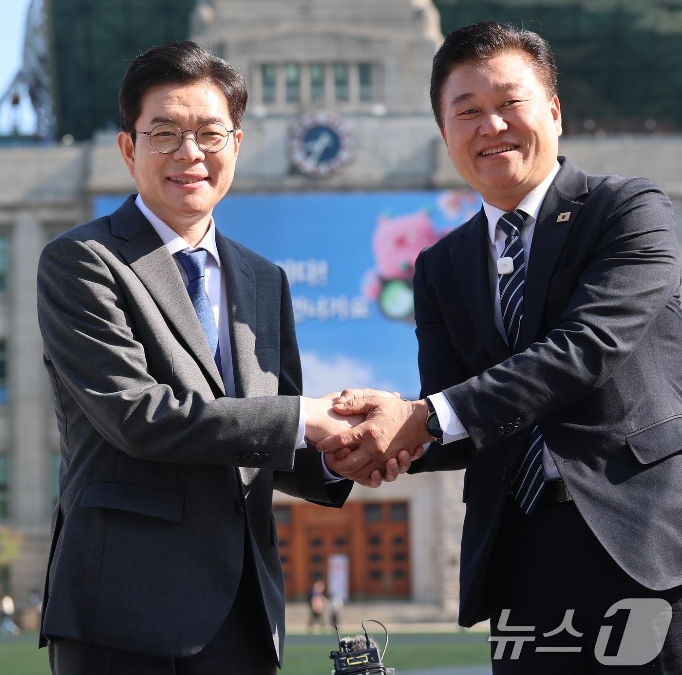 본문 이미지 - 정원오 더불어민주당 서울시장 후보와 신용한 더불어민주당 충북도지사 후보가 13일 서울시청 앞 광장에서 열린 "대한민국의 미래를 함께 열겠습니다＂ 서울-충북 상생 협약식에서 협약서에 서명한 후 악수를 나누고 있다. 2026.5.13 ⓒ 뉴스1 오대일 기자