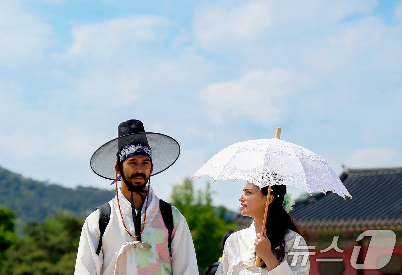 본문 이미지 - 서울 낮 최고기온 28도까지 오르며 초여름 날씨를 보인 13일 오후 서울 종로구 광화문에서 외국인 관광객들이 양산을 쓴 채 지나가고 있다. 2026.5.13 ⓒ 뉴스1 조연우 인턴기자