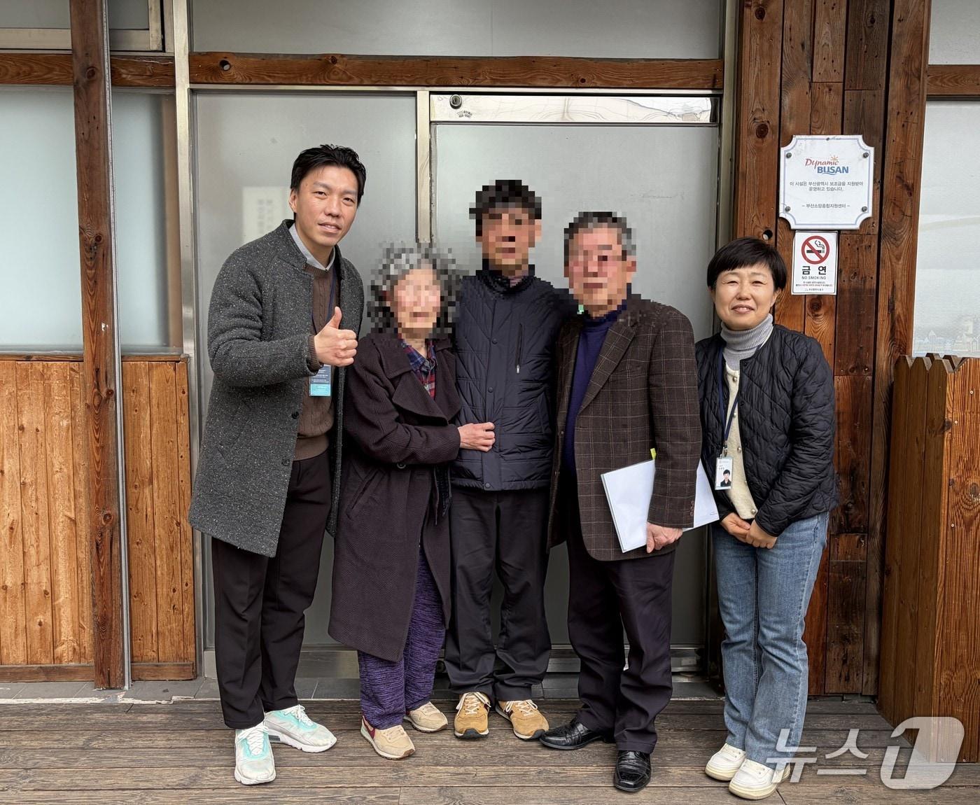 본문 이미지 - 10년만에 가족과 상봉한 A 씨와 관계자들이 기념촬영을 하는 모습 (부산 동구 제공. 재판매 및 DB금지)