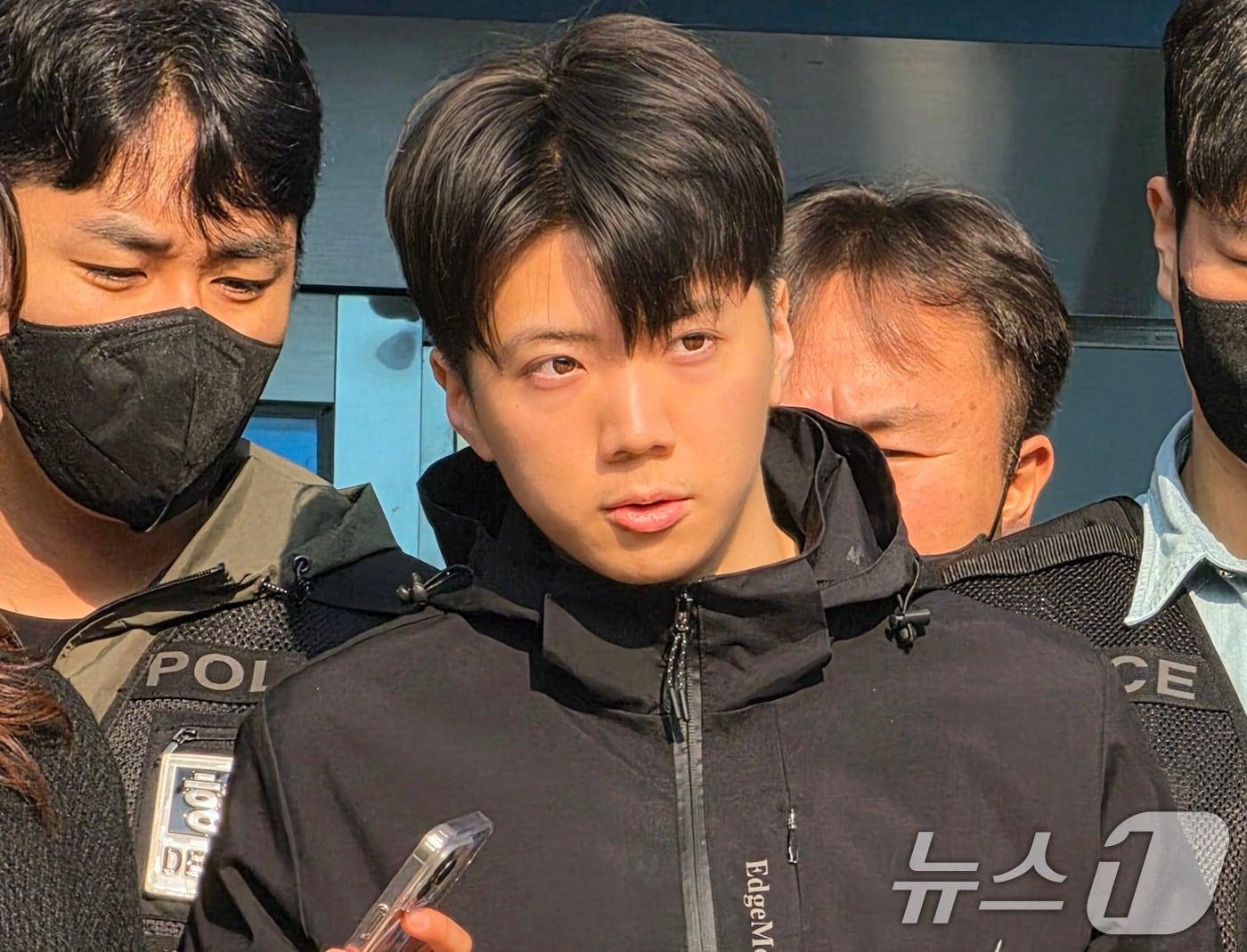 본문 이미지 - 어린이날 광주 도심에서 일면식 없는 여고생을 살해해 살인·살인미수 등의 혐의를 받는 장윤기(23)가 14일 오전 광주 서부경찰서에서 검찰에 송치되고 있다. 장윤기는 이날 광주에선 처음으로 신상이 공개됐다. 2026.5.14 ⓒ 뉴스1 이수민 기자