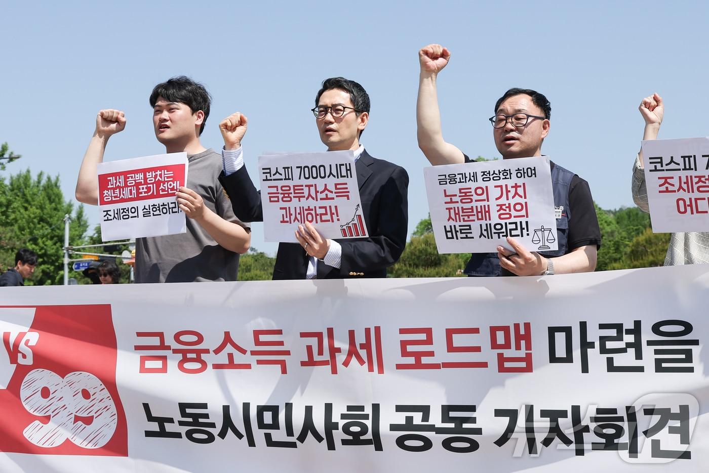 본문 이미지 - 민주노총과 한국노총을 비롯한 노동시민사회단체 관계자들이 14일 서울 종로구 청와대 분수대 앞에서 열린 ‘코스피 7000 시대, 금융과세 정상화 로드맵 마련 촉구 기자회견’에서 구호를 외치고 있다. 2026.5.14 ⓒ 뉴스1 이종수 인턴기자