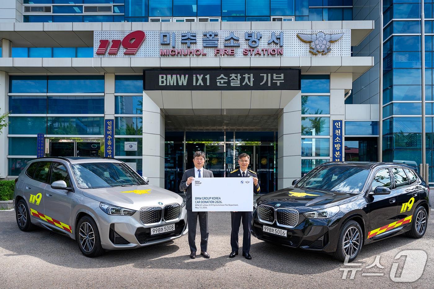 본문 이미지 - 13일 인천 미추홀구 인천소방본부에서 고흥범 BMW 그룹 코리아 대외협력본부 본부장(왼쪽)과 임원섭 인천소방본부 본부장이 BMW 준중형 전기 스포츠액티비티차(SAV) 'iX1'을 배경으로 기념 사진을 촬영한 모습. 이날 BMW 그룹 코리아는 인천소방본부에 iX1 2대를 다목적 순찰차로 기증했다(BMW 그룹 코리아 제공). 2026.5.13