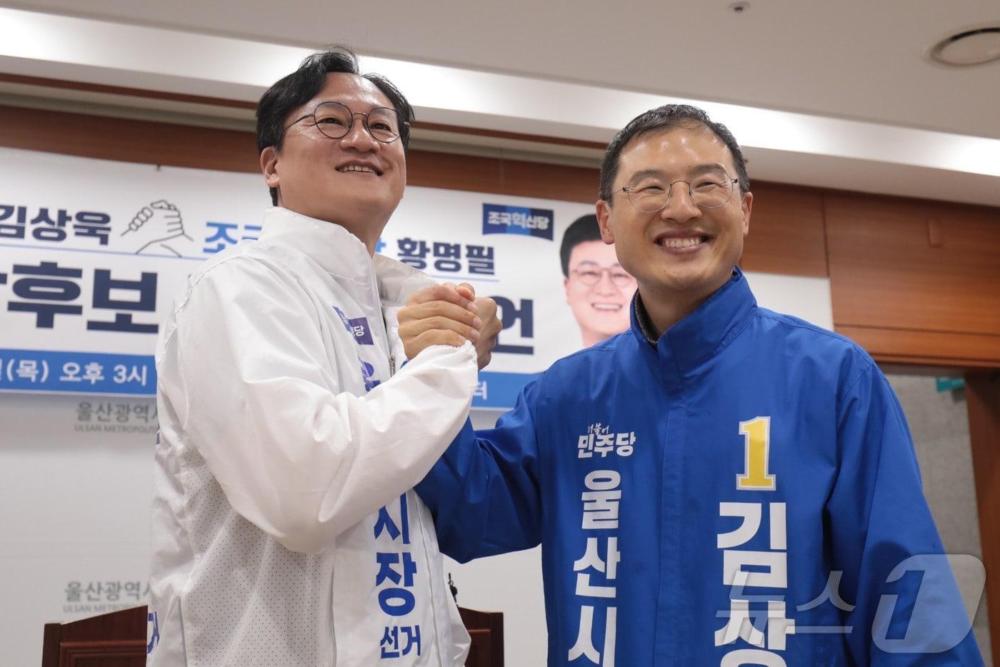 본문 이미지 - 왼쪽부터 황명필 조국혁신당 울산시장 예비후보와 김상욱 더불어민주당 울산시장 예비후보가 14일 울산시의회 프레스센터에서 후보 단일화 선언 회견을 열고 손을 맞잡고 있다. ⓒ 뉴스1 김세은 기자