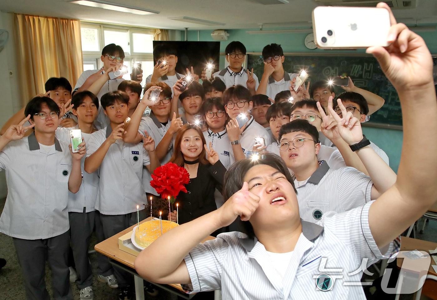 본문 이미지 - 스승의 날인 15일 오전 대구 북구 성광고 1학년 교실에서 담임 교사와 학생들이 축하 케이크에 불을 밝혀 기념 촬영을 하고 있다. 학교 측은 학생들이 꽃이나 선물을 가져오지 않도록 미리 공지하고, 학교 운영 예산 가운데 예비비로 케이크와 종이 카네이션을 준비해 스승의 날 축하 행사를 진행했다. 2026.5.15 ⓒ 뉴스1 공정식 기자