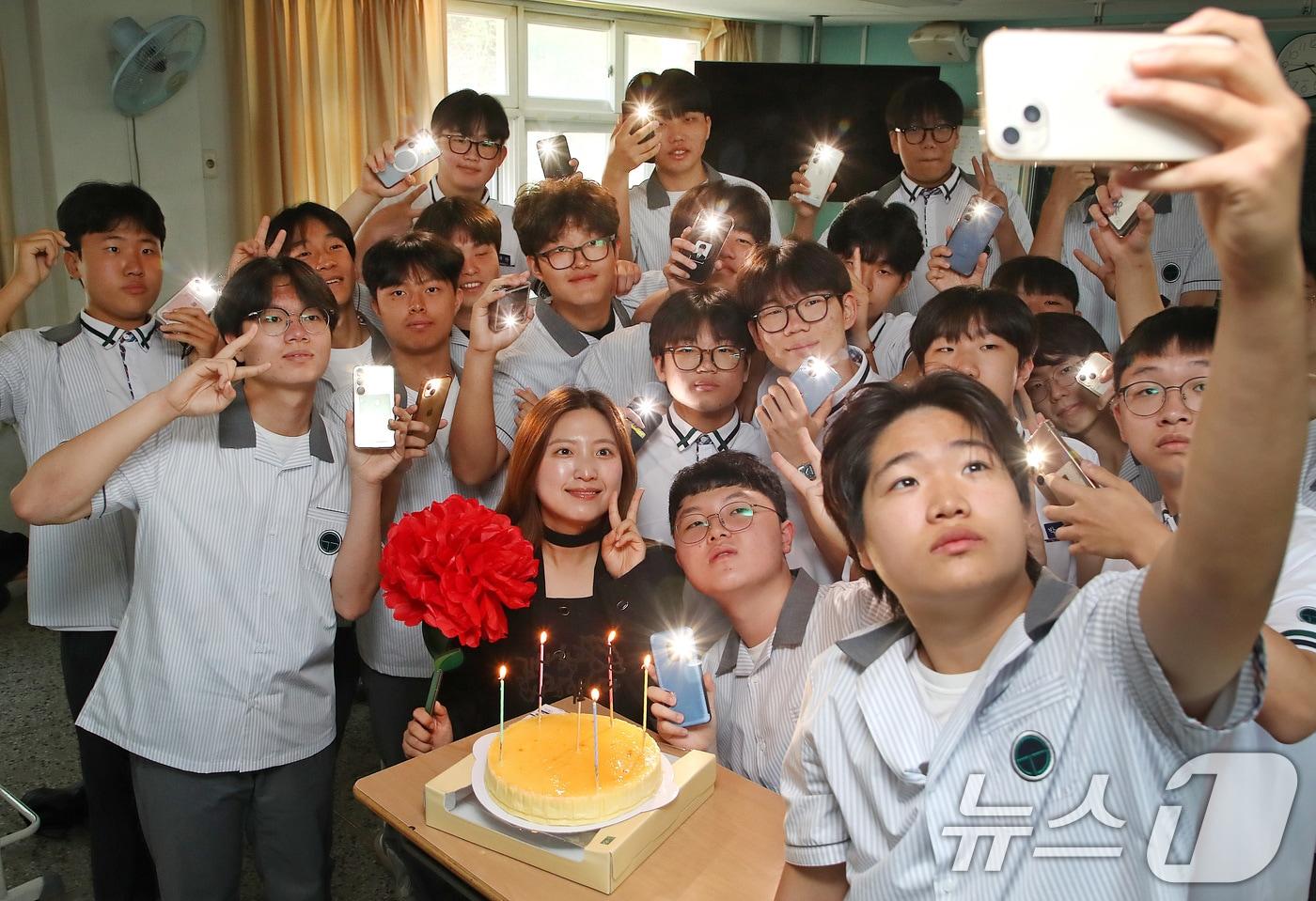 본문 이미지 - 스승의 날인 15일 오전 대구 북구 성광고 1학년 교실에서 담임 교사와 학생들이 축하 케이크에 불을 밝혀 기념 촬영을 하고 있다. 학교 측은 학생들이 꽃이나 선물을 가져오지 않도록 미리 공지하고, 학교 운영 예산 가운데 예비비로 케이크와 종이 카네이션을 준비해 스승의 날 축하 행사를 진행했다. 2026.5.15 ⓒ 뉴스1 공정식 기자