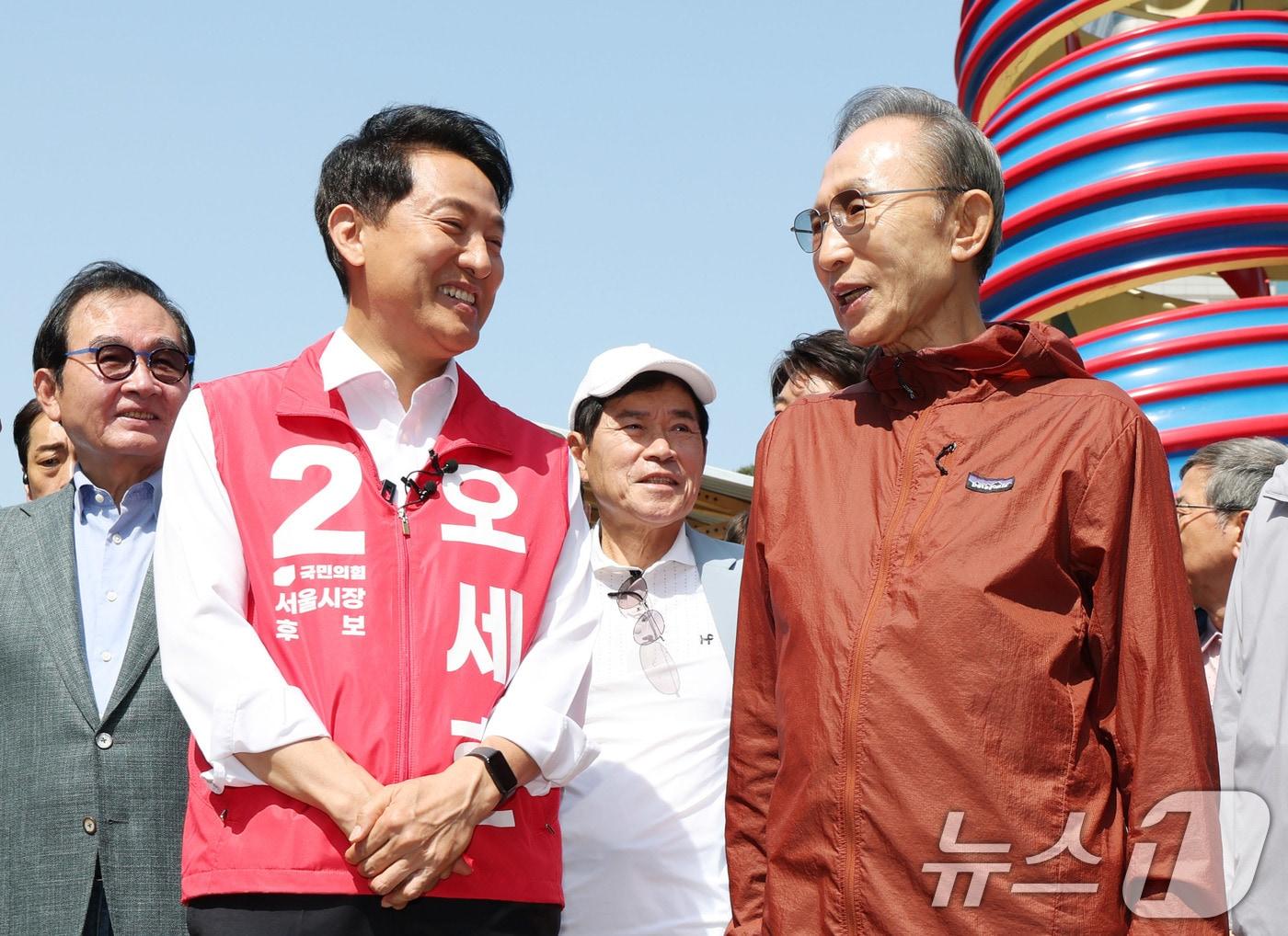 본문 이미지 - 오세훈 국민의힘 서울시장 후보가 15일 서울 청계천에서 만난 이명박 전 대통령과 시민들에게 인사하고 있다. 2026.5.15 ⓒ 뉴스1 박지혜 기자