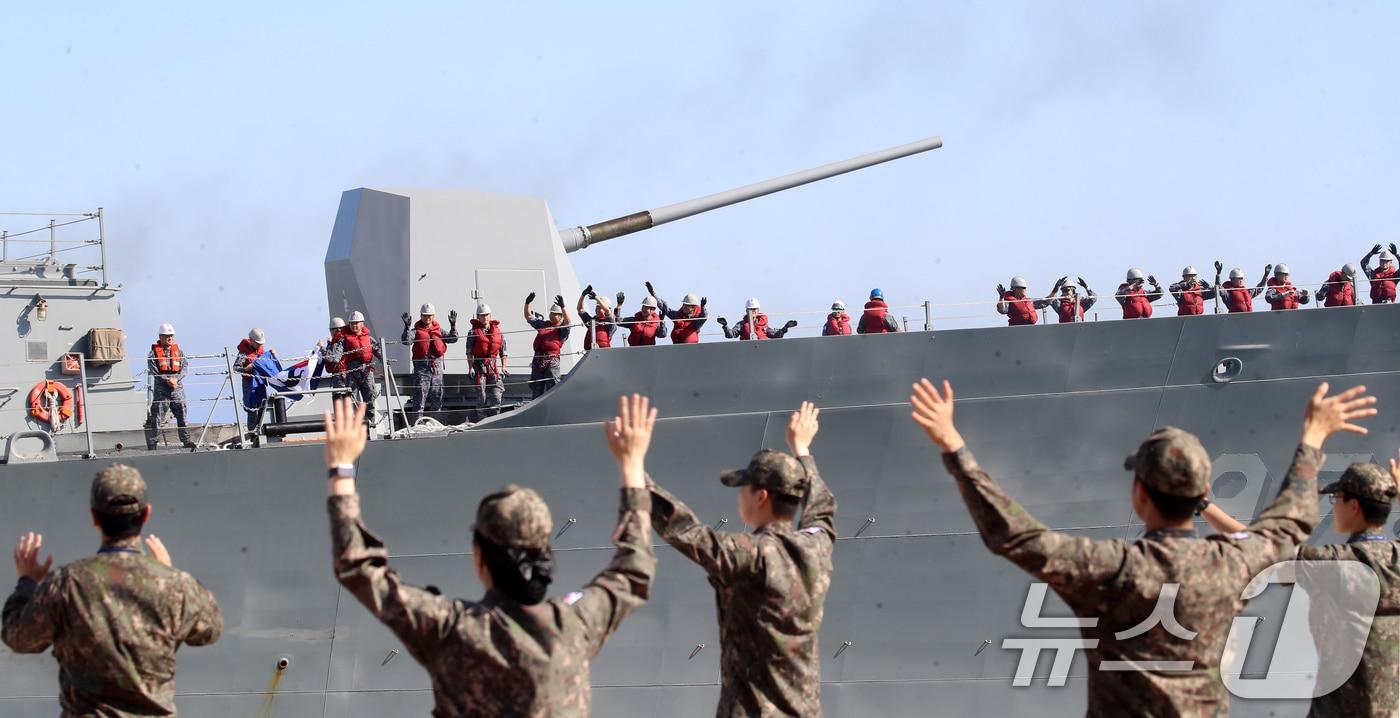 본문 이미지 - 지난 5월 15일 오후 부산 남구 해군작전사령부 부산적전기지에서 해군 청해부대 48진 왕건함(DDH-Ⅱ·4400톤급) 승조원들이 동료들의 환송을 받으며 출항하고 있다. 2026.5.15 ⓒ 뉴스1 윤일지 기자