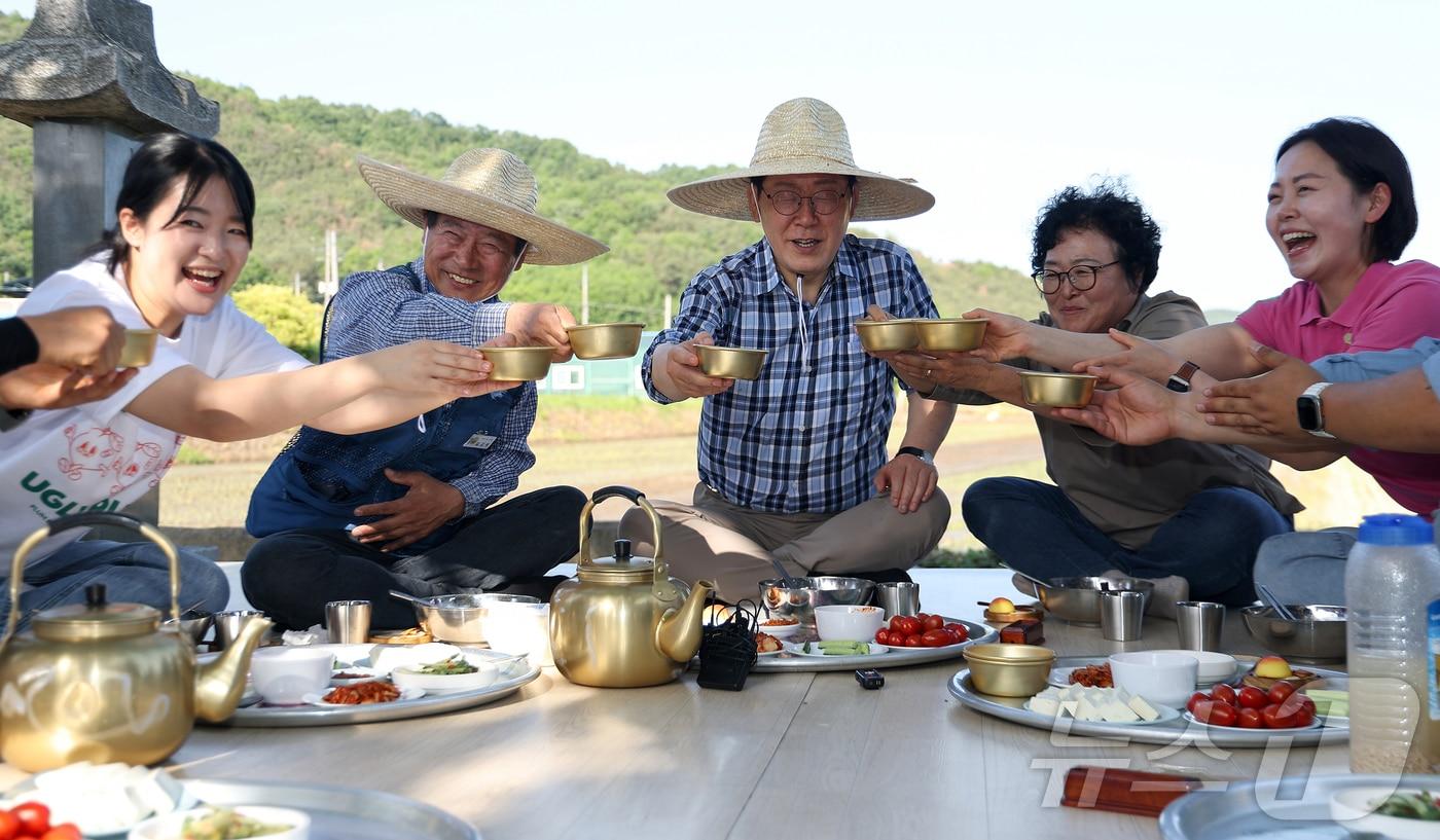 본문 이미지 - 이재명 대통령이 15일 대구 군위군 소보면 모내기 현장을 방문해 주민들과 새참 간담회를 하고 있다. 2026.5.15 ⓒ 뉴스1 허경 기자