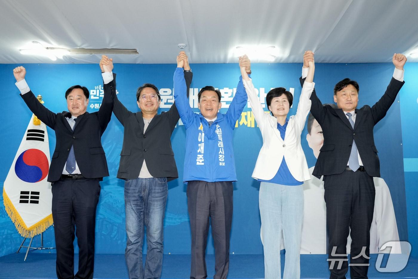 본문 이미지 - 이재준 더불어민주당 경기 수원시장 후보(가운데)가 16일 수원시 선거사무소 개소식을 열었다. 사진은 수원 지역 국회의원들과 손을 맞잡고 만세를 하고 있는 모습. (이 후보 선거캠프 제공. 재판매 및 DB 금지) 2026.5.16/뉴스1 