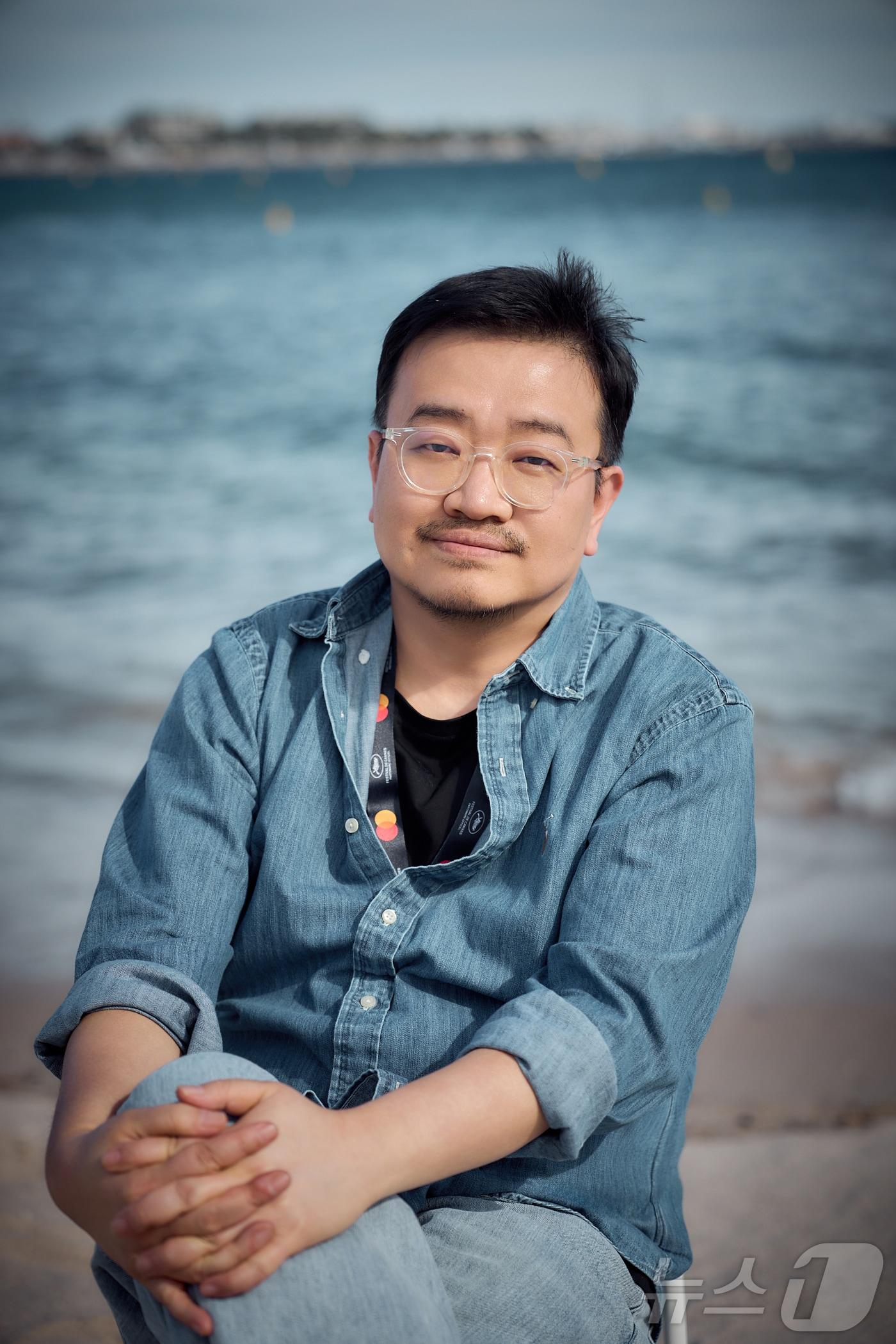 본문 이미지 - 제79회 칸 국제영화제가 열리고 있는 16일(현지 시각) 프랑스 남부 소도시 칸 팔레 데 페스티발(Palais des Festivals) 한국영화진흥위원회 부스 인근 크루아제트 해변에서 열린 영화 ‘군체’ 출연진 화보 촬영에서 연상호 감독이 포즈를 취하고 있다. (쇼박스 제공. 재판매 및 DB 금지) 2026.5.17 ⓒ 뉴스1 이준성 특파원
