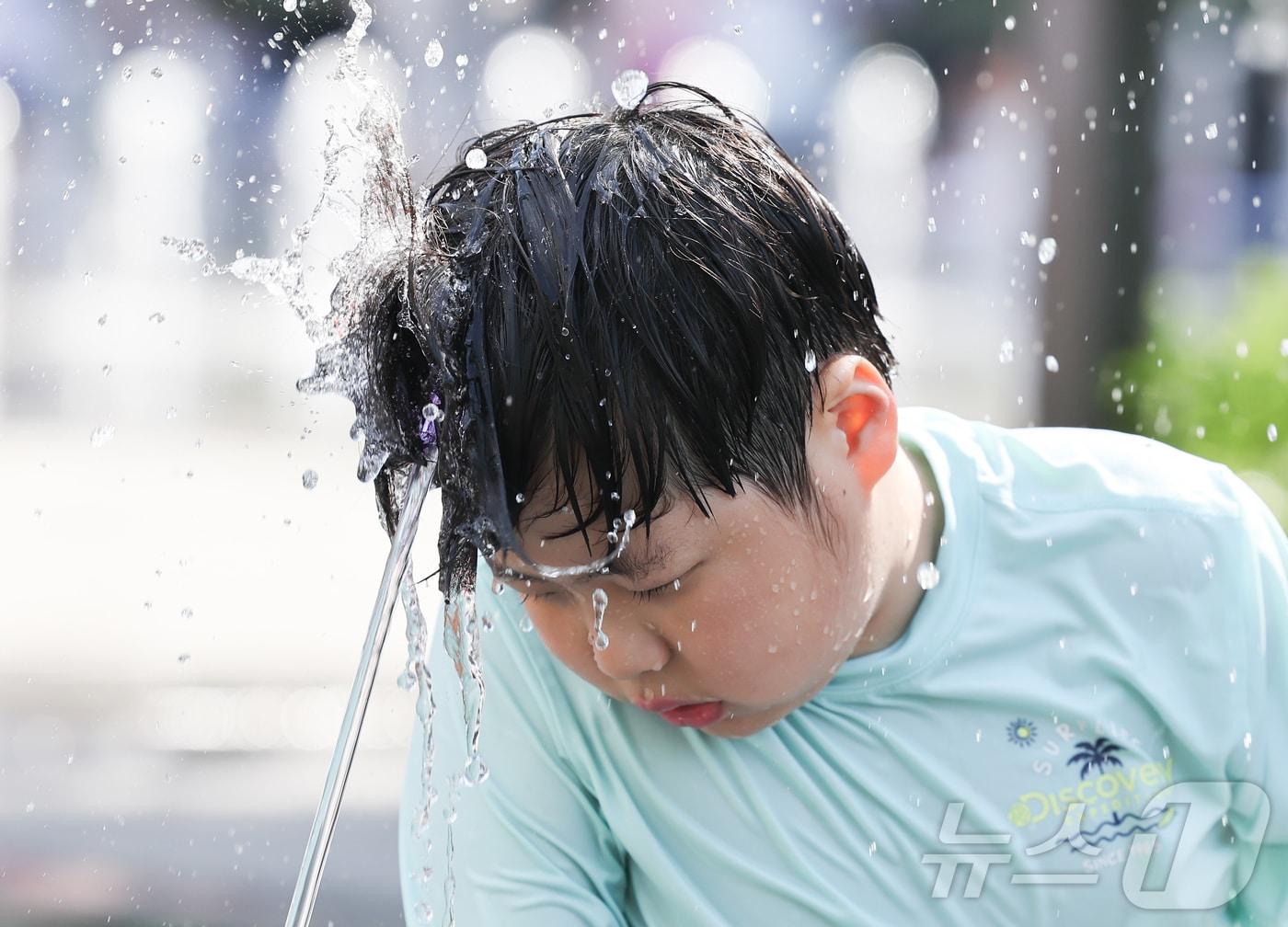 본문 이미지 - 낮 기온이 오르며 초여름 날씨를 보인 17일 서울 종로구 광화문광장 분수대에서 한 어린이가 물놀이를 하며 더위를 식히고 있다. 2026.5.17 ⓒ 뉴스1 이종수 인턴기자