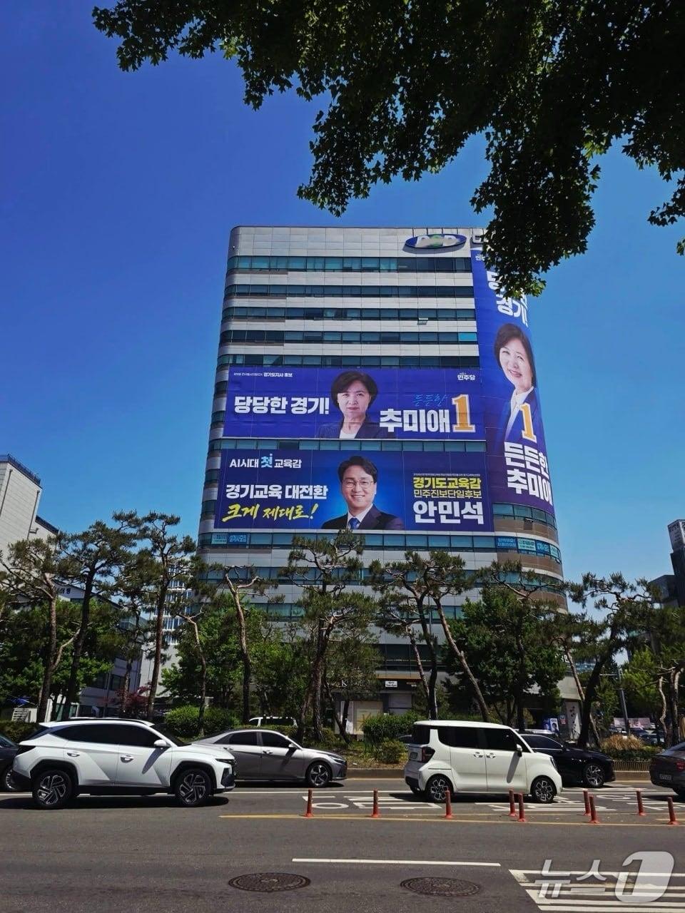 본문 이미지 -  수원시청 사거리 한 건물에 추미애 경기지사 후보와 안민석 경기교육감 후보 대형 현수막이 걸려 있다. 
