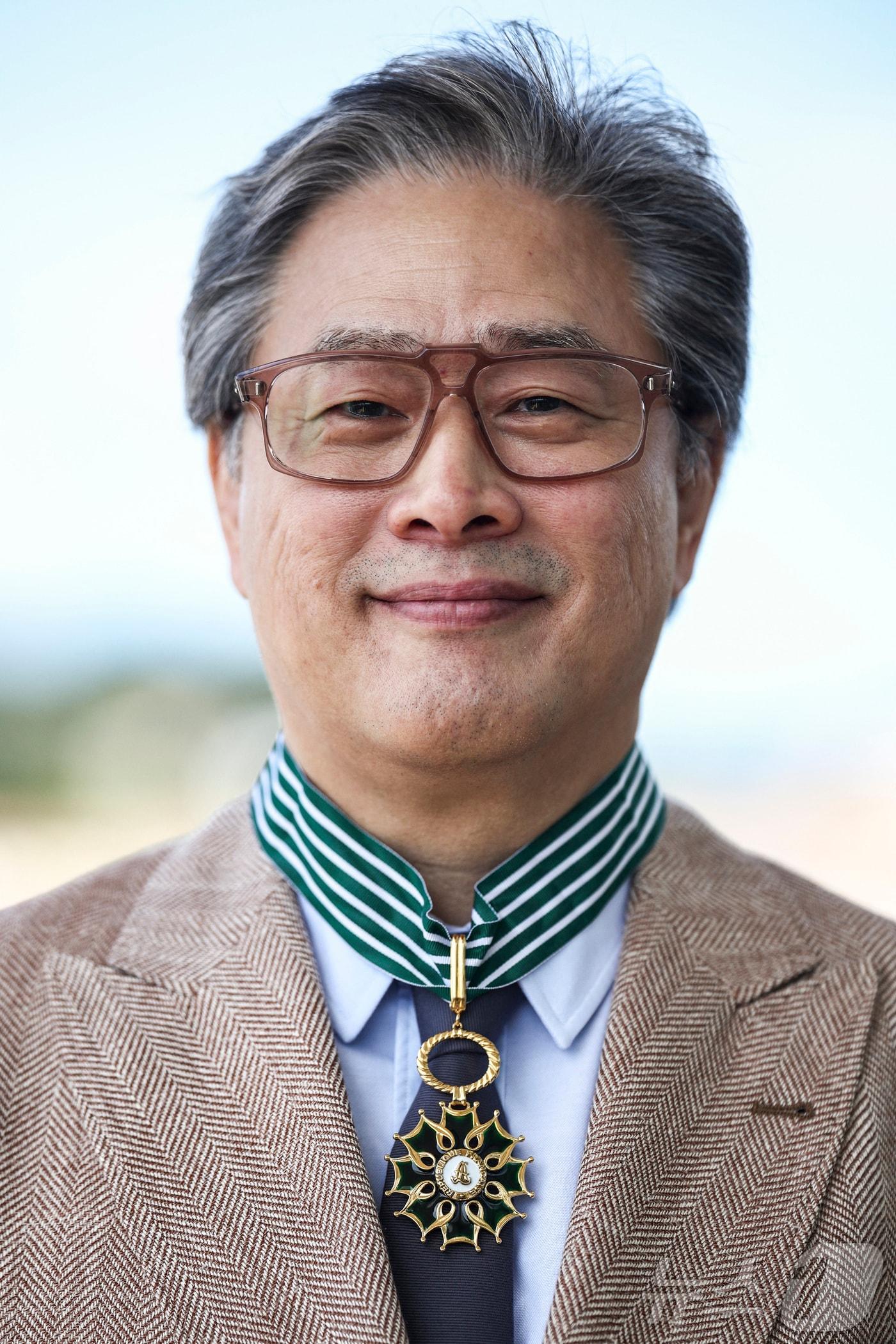 본문 이미지 - 제79회 칸 국제영화제 경쟁부문 심사위원장인 박찬욱 감독이 17일(현지 시각) 프랑스 남부 칸에서 열린 프랑스 문화예술공로훈장 수훈식에서 최고 등급인 ‘코망되르’를 받은 뒤 훈장을 목에 걸고 있다. 2026.5.17 ⓒ 뉴스1 ⓒ 로이터=뉴스1