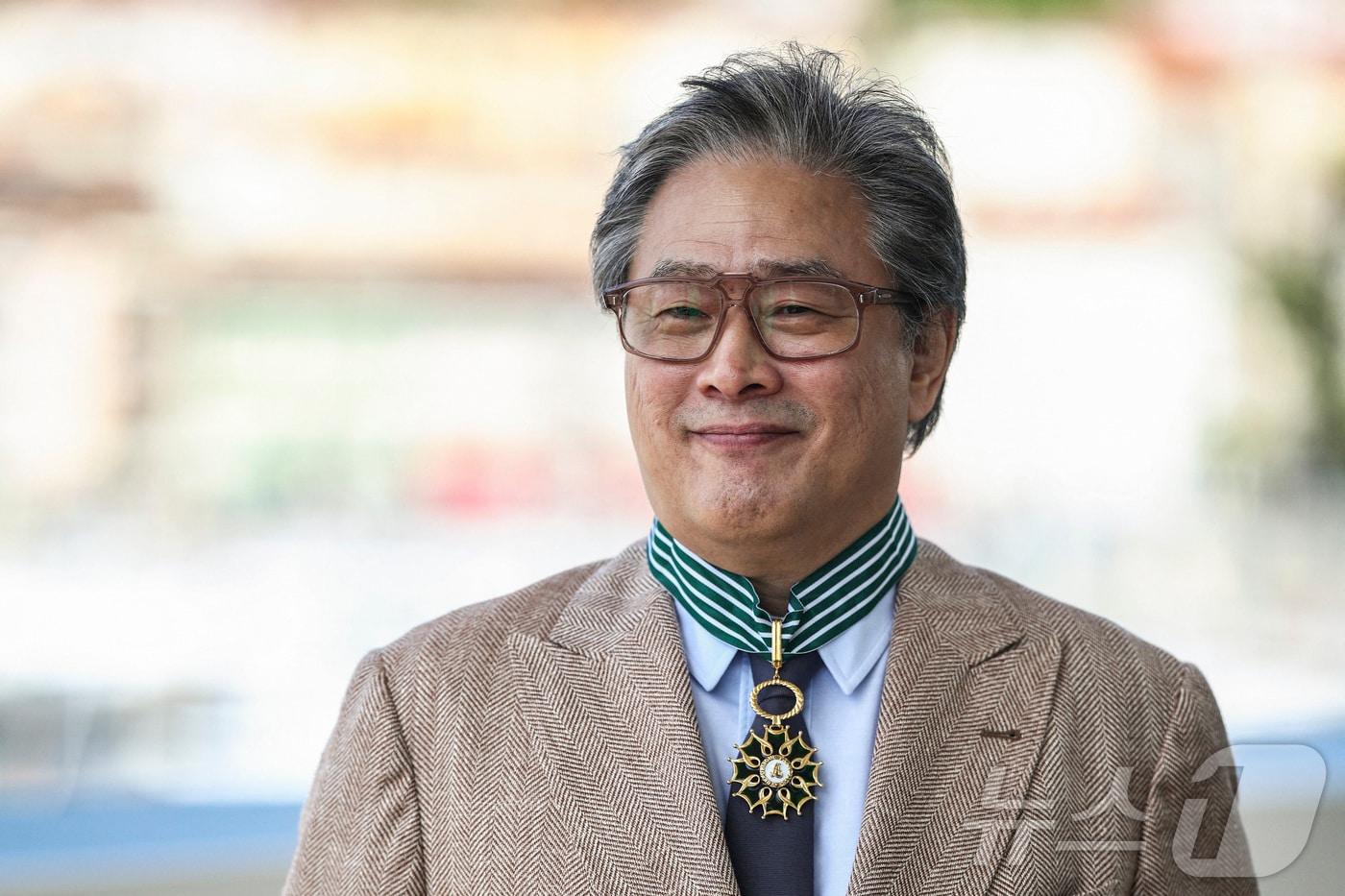 본문 이미지 - 제79회 칸 영화제 심사위원장인 박찬욱 감독이 17일(현지시간) 프랑스 칸에서 열린 제79회 칸 영화제에서 문화예술공로훈장 최고등급인 코망되르 메달을 수여받은 후 웃음짓고 있다. ⓒ 로이터=뉴스1