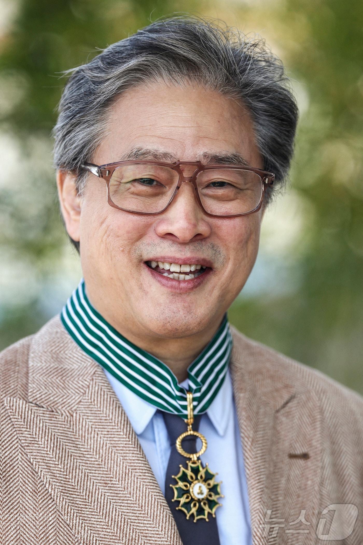 본문 이미지 - 제79회 칸 국제영화제 경쟁부문 심사위원장인 박찬욱 감독이 17일(현지시간) 프랑스 남부 칸에서 프랑스 문화예술공로훈장 최고 등급인 ‘코망되르’를 받은 뒤 훈장을 목에 걸고 있다. 2026.5.17 ⓒ 뉴스1 ⓒ 로이터=뉴스1