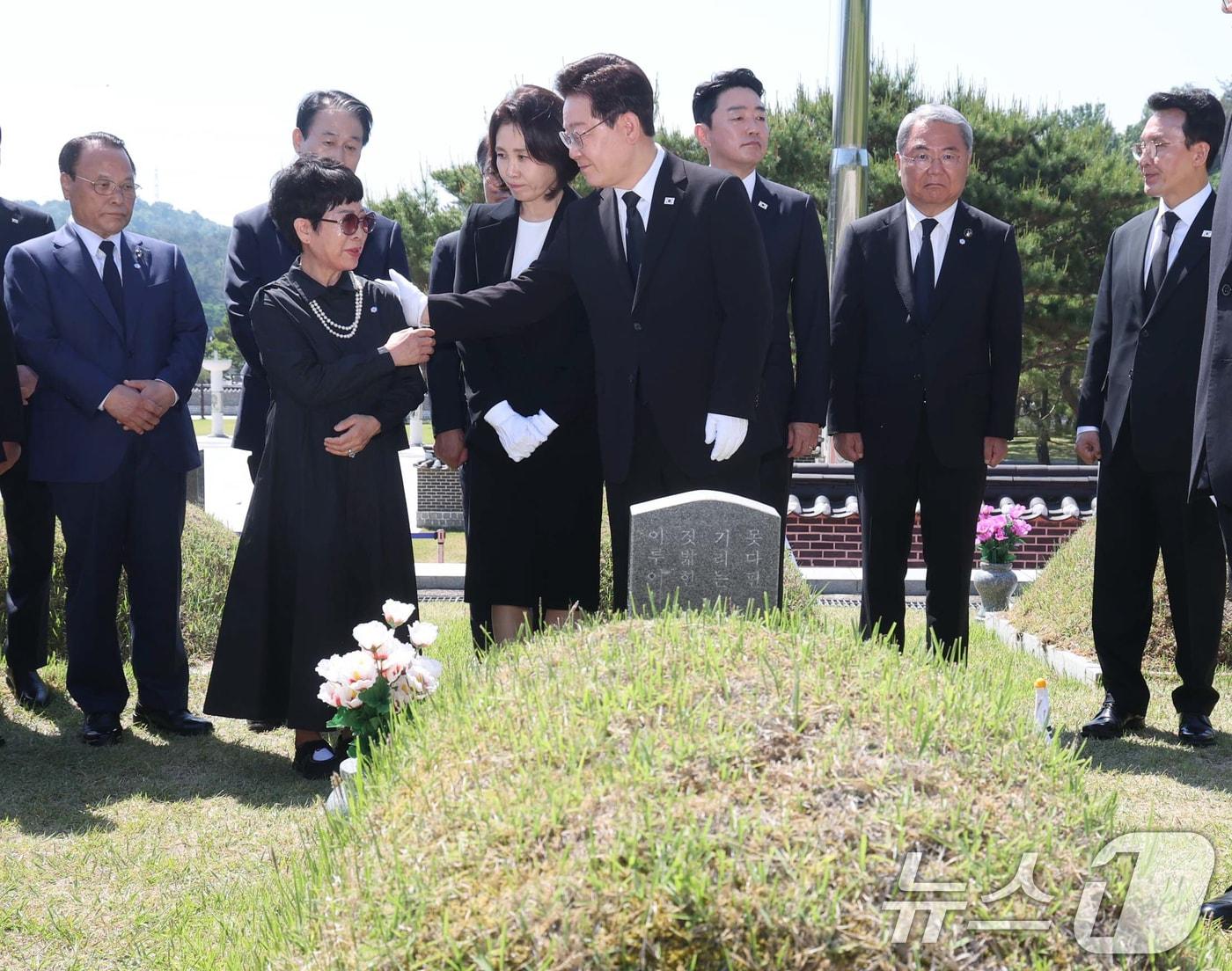 본문 이미지 - 이재명 대통령과 김혜경 여사가 18일 오전 광주 북구 운정동 국립 5·18민주묘지을 찾아 故 박인배 묘역에 헌화한 뒤 유가족을 위로하고 있다. 2026.5.18 ⓒ 뉴스1 이재명 기자