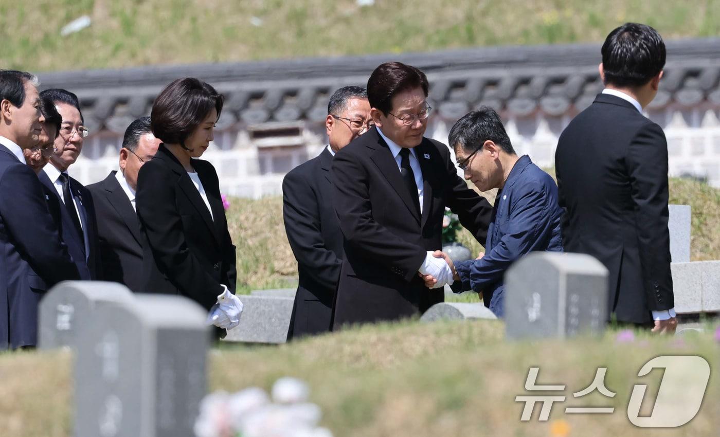 본문 이미지 - 이재명 대통령과 김혜경 여사가 18일 오전 광주 북구 운정동 국립 5·18민주묘지을 찾아 故 양창근 묘역에 헌화한 뒤 유가족을 위로하고 있다. ⓒ 뉴스1 이재명 기자