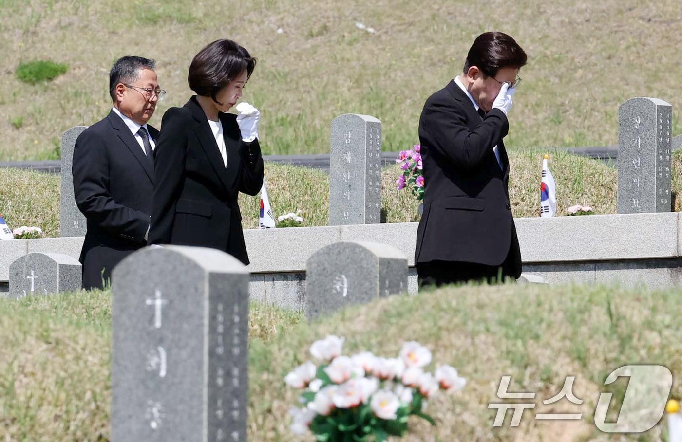 본문 이미지 - 이재명 대통령과 김혜경 여사가 18일 오전 광주 북구 운정동 국립 5·18민주묘지에서 묘역을 둘러보며 눈물을 닦고 있다. 2026.5.18 ⓒ 뉴스1 이재명 기자