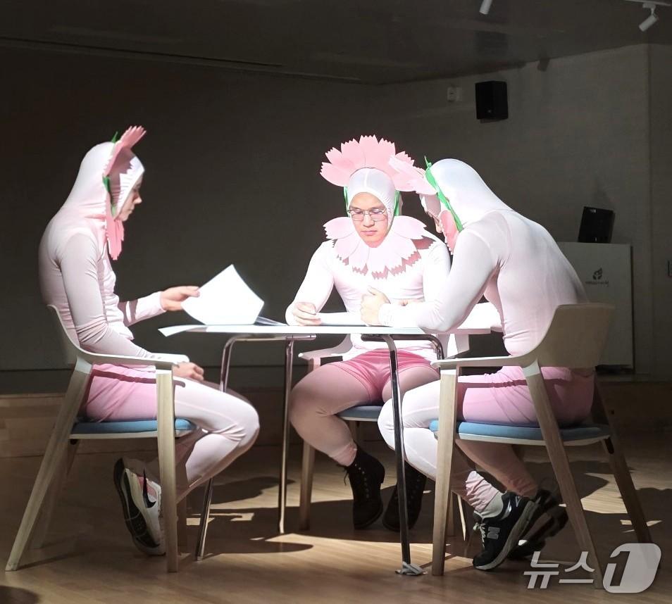 본문 이미지 - 분홍색 쫄쫄이 의상을 입고 머리에 닭 볏 모자를 쓴 채 '진지 모드'의 영상을 촬영하고 있는 제천시청 공무원들.(제천시청 제공. 재판매 및 DB금지)/뉴스1