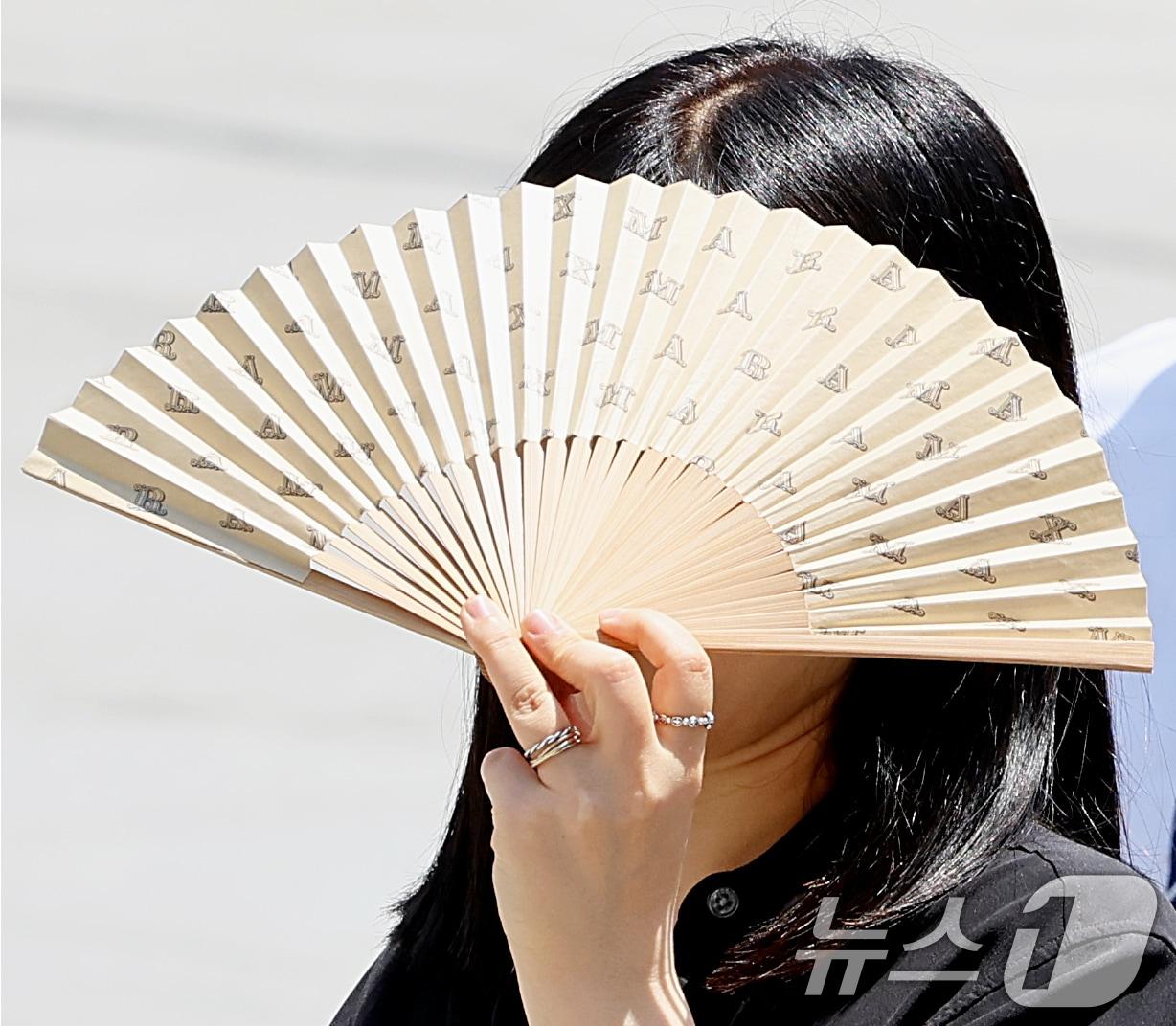 본문 이미지 - 맑은 날씨 속 낮 최고기온이 30도 안팎까지 오른 18일 오후 서울 광화문광장에서 시민이 부채로 햇살을 가리며 발걸음을 옮기고 있다. 2026.5.18 ⓒ 뉴스1 조연우 인턴기자