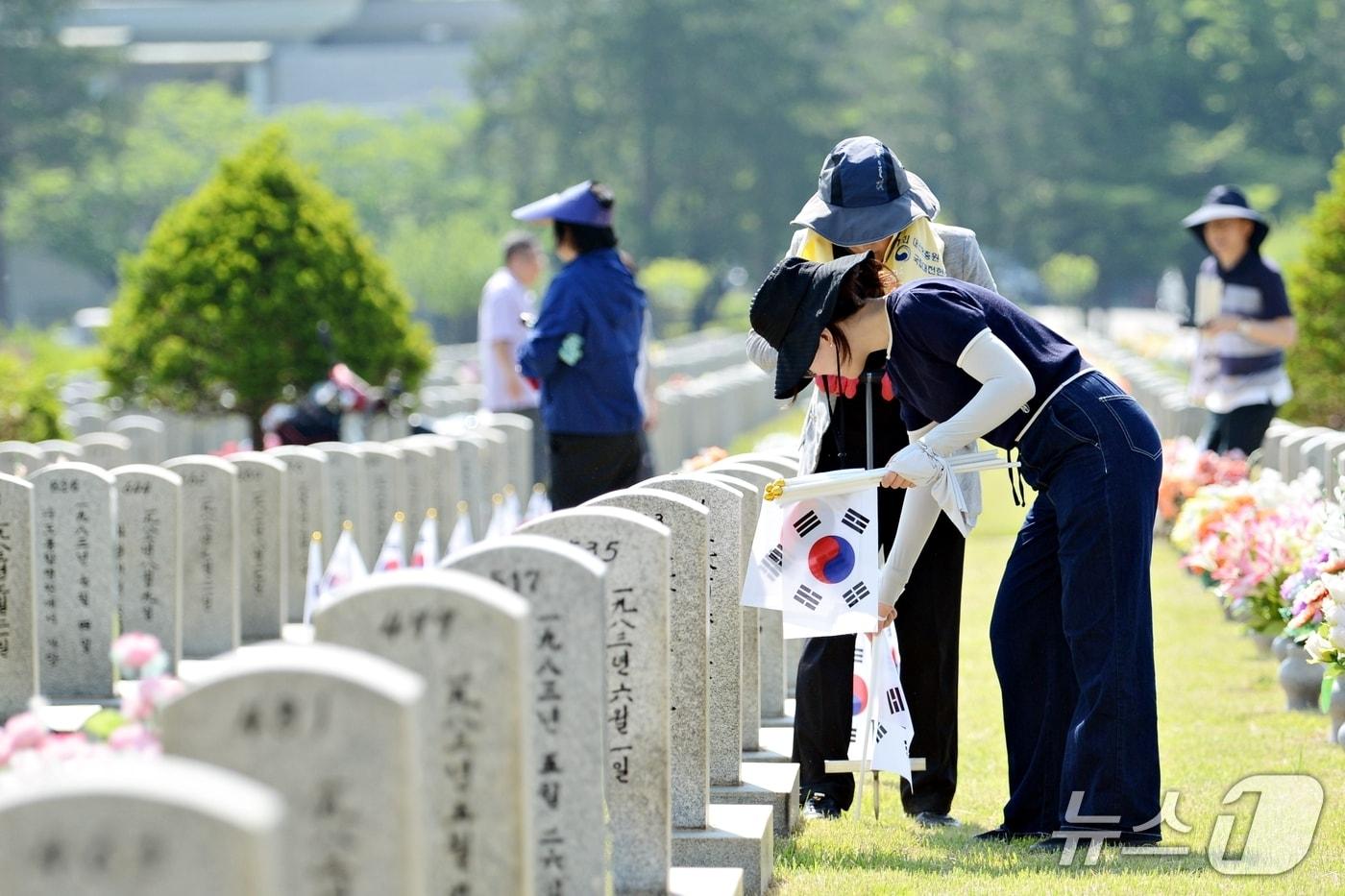 본문 이미지 - 태극기 꽂기 봉사활동 모습.(대전현충원 제공. 재판매 및 DB금지)/뉴스1