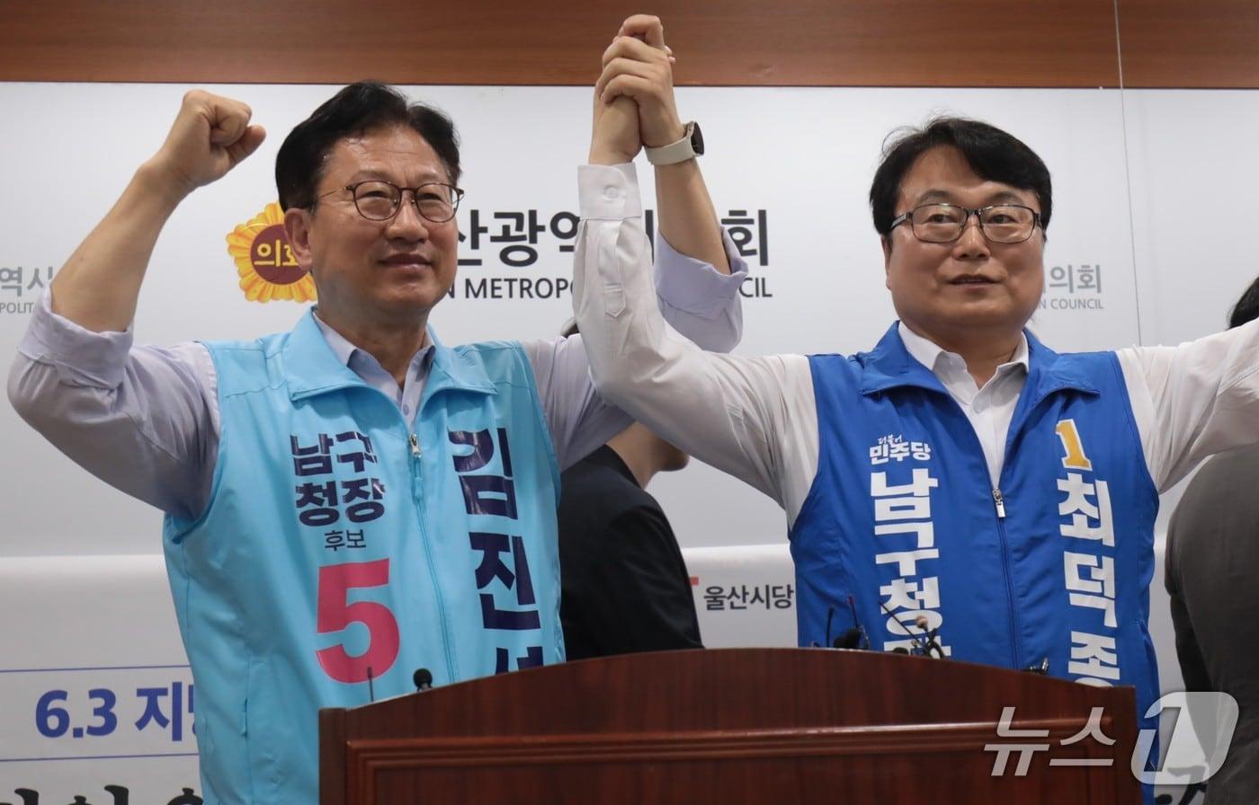 본문 이미지 - 울산 남구청장에 출마하는 최덕종 더불어민주당 후보와 김진석 진보당 후보가 지난 15일 울산시의회 프레스센터에서 손을 맞잡고 있다.2026.05.16.ⓒ 뉴스1 김세은 기자