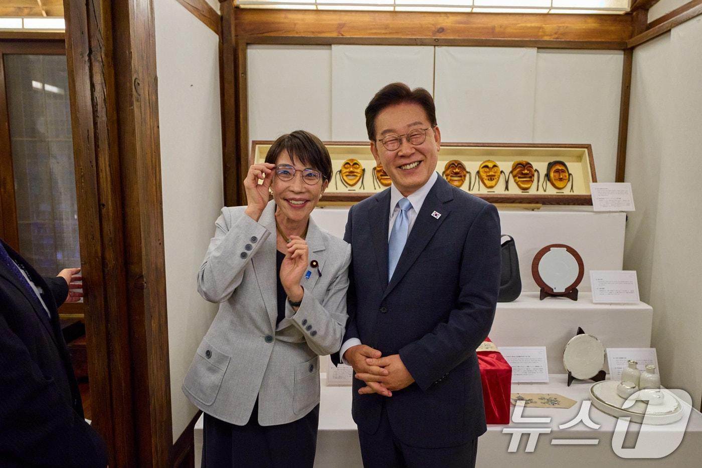 본문 이미지 - 이재명 대통령이 19일 경북 안동의 한 호텔에서 다카이치 사나에 일본 총리가 선물한 안경테을 착용한 후 기념촬영을 하고 있다. (청와대 제공. 재판매 및 DB 금지) 2026.5.19 ⓒ 뉴스1 이재명 기자