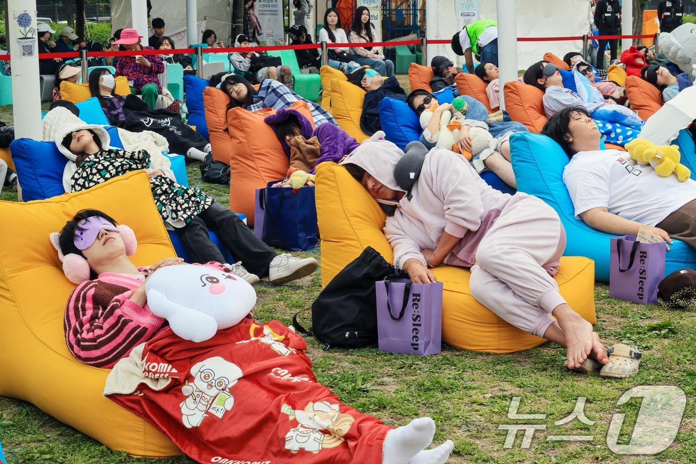 본문 이미지 - 2일 서울 영등포구 한강공원 멀티플라자에서 열린 ‘2026 한강 잠퍼자기 대회’에 참가한 시민들이 낮잠을 자고 있다.2026.5.2 ⓒ 뉴스1 이호윤 기자