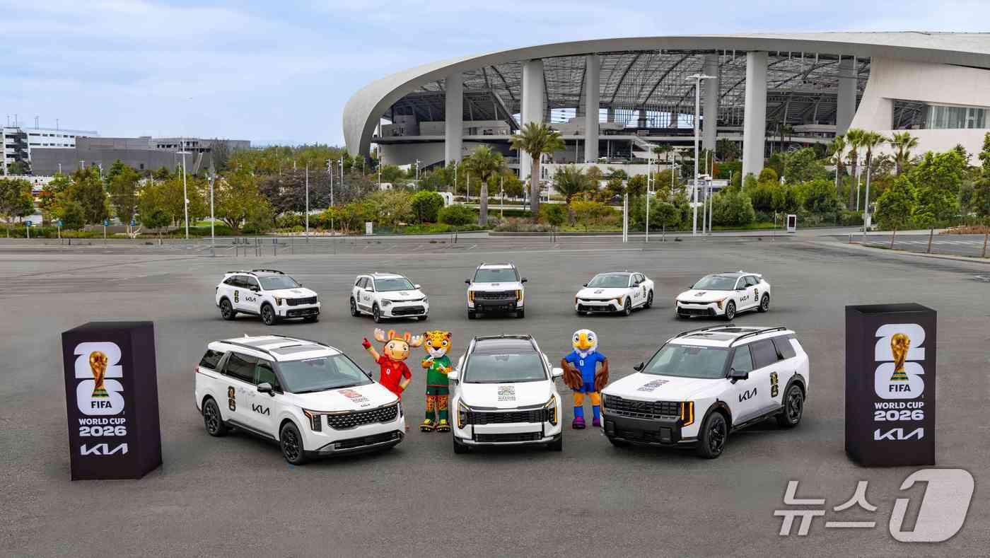 본문 이미지 - 기아의 FIFA 월드컵 2026 ™ 공식 지원 차량과 월드컵 공식 마스코트. 차량은 (앞줄 왼쪽부터) 카니발 하이브리드, 스포티지, 텔루라이드 하이브리드 X-Line (뒷줄 왼쪽부터) 쏘렌토, 니로, 텔루라이드 X-Pro, K4, K4해치백. (기아 제공)