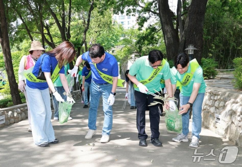 본문 이미지 - 달빛동맹 교류 행사에 참가한 iM뱅크와 광주은행의 봉사단원들이 대구 중구 근대골목 일대에서 환경정화 활동을 펼치고 있다.(iM뱅크 제공, 재판매 및 DB 금지)