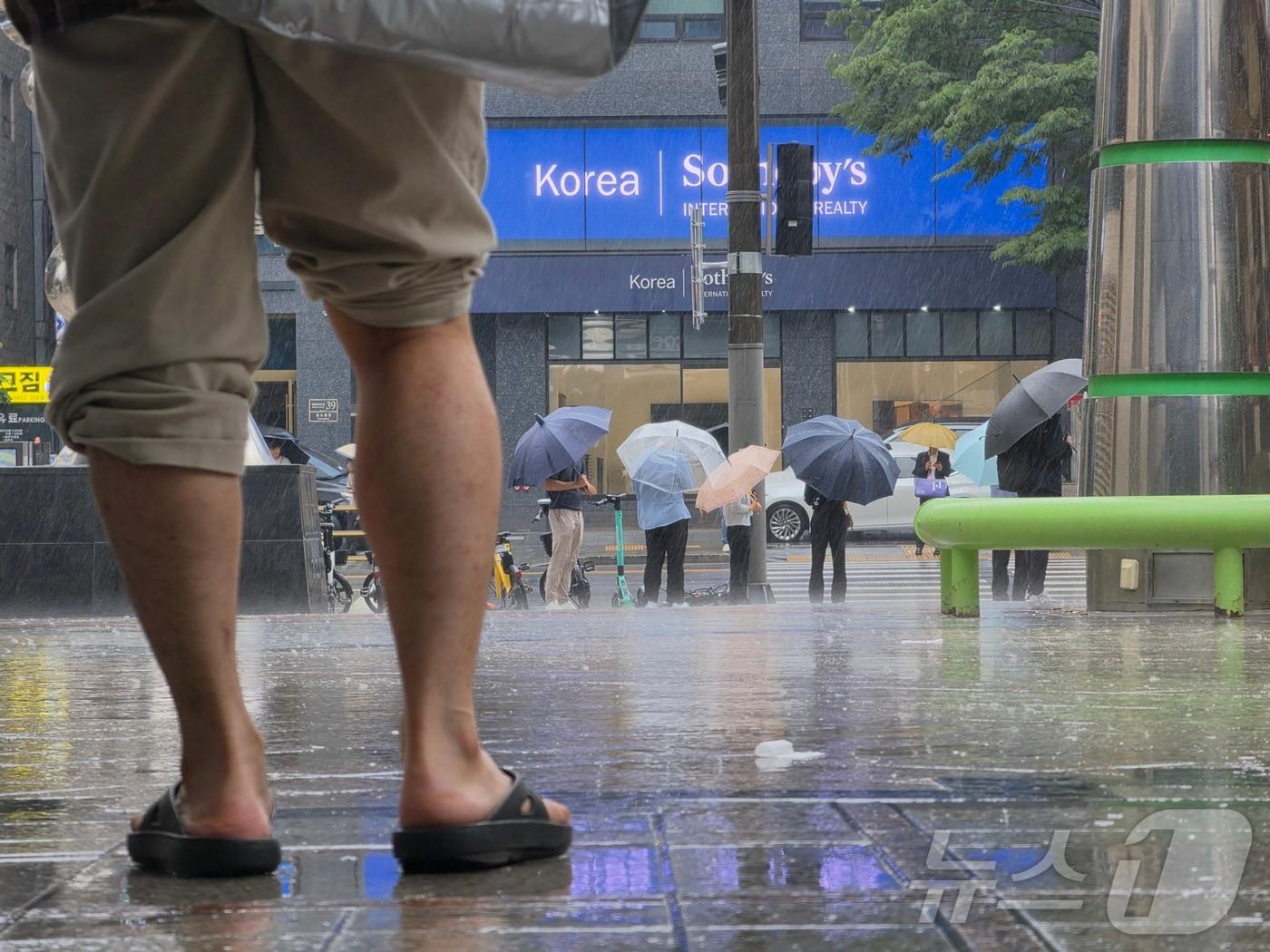 본문 이미지 - 20일 서울 강남구 삼성동 코엑스에 비가 내리자 시민들이 우산을 펼쳐들고 있다. 2026.5.20 ⓒ 뉴스1 황덕현 기후환경전문기자
