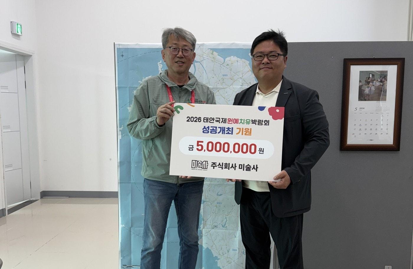 본문 이미지 - 오진기 태안박람회 조직위 사무총장(왼쪽)이 이준석 미술사 대표로부터 500만 원을 기탁받고 기념찰영을 하고 있다.(조직위 제공. 재판매 및 DB금지)/뉴스1