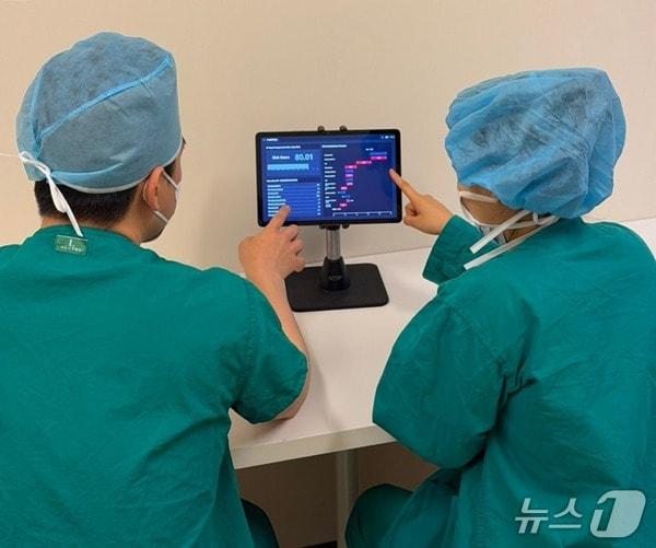 본문 이미지 - 서울아산병원 의료진이 수술 전 전자의무기록(EMR)을 바탕으로 환자의 수술 후 중증 이벤트인 사망 위험을 예측하는 AI 기술이 적용된 'PreOPRisk'(프리오피리스크)를 테스트하고 있는 모습. (병원 제공)