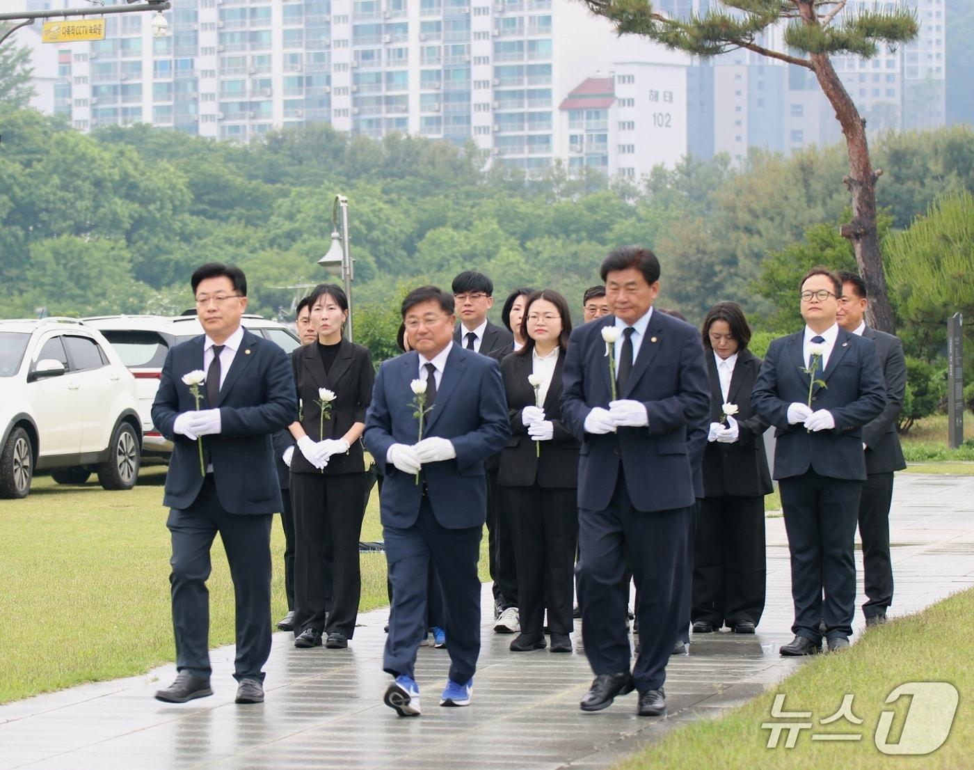 본문 이미지 - 지방선거에 출마한 민주당 경기 광주시 각 후보들이 20일 호국보훈공원에서 순국선열들을 기리기 위해 현충탑으로 걸어가고 있다.(박관열 후보측 제공)