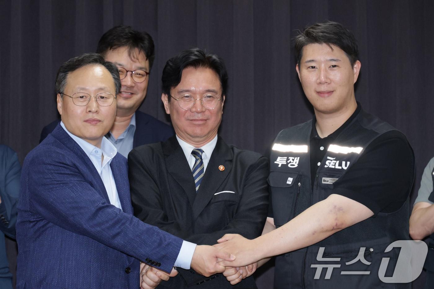 본문 이미지 - 20일 경기도 수원시 장안구 경기고용노동청에서 열린 삼성전자 임금협상을 마친 후 여명구 삼성전자 DS(디바이스솔루션·반도체 사업 담당) 피플팀장과 김영훈 고용노동부 장관, 최승호 삼성그룹 초기업노동조합 삼성전자지부 위원장이 잠정 합의한에 서명한 후 손을 맞잡고 있다. (공동취재) 2026.5.20 ⓒ 뉴스1 김영운 기자